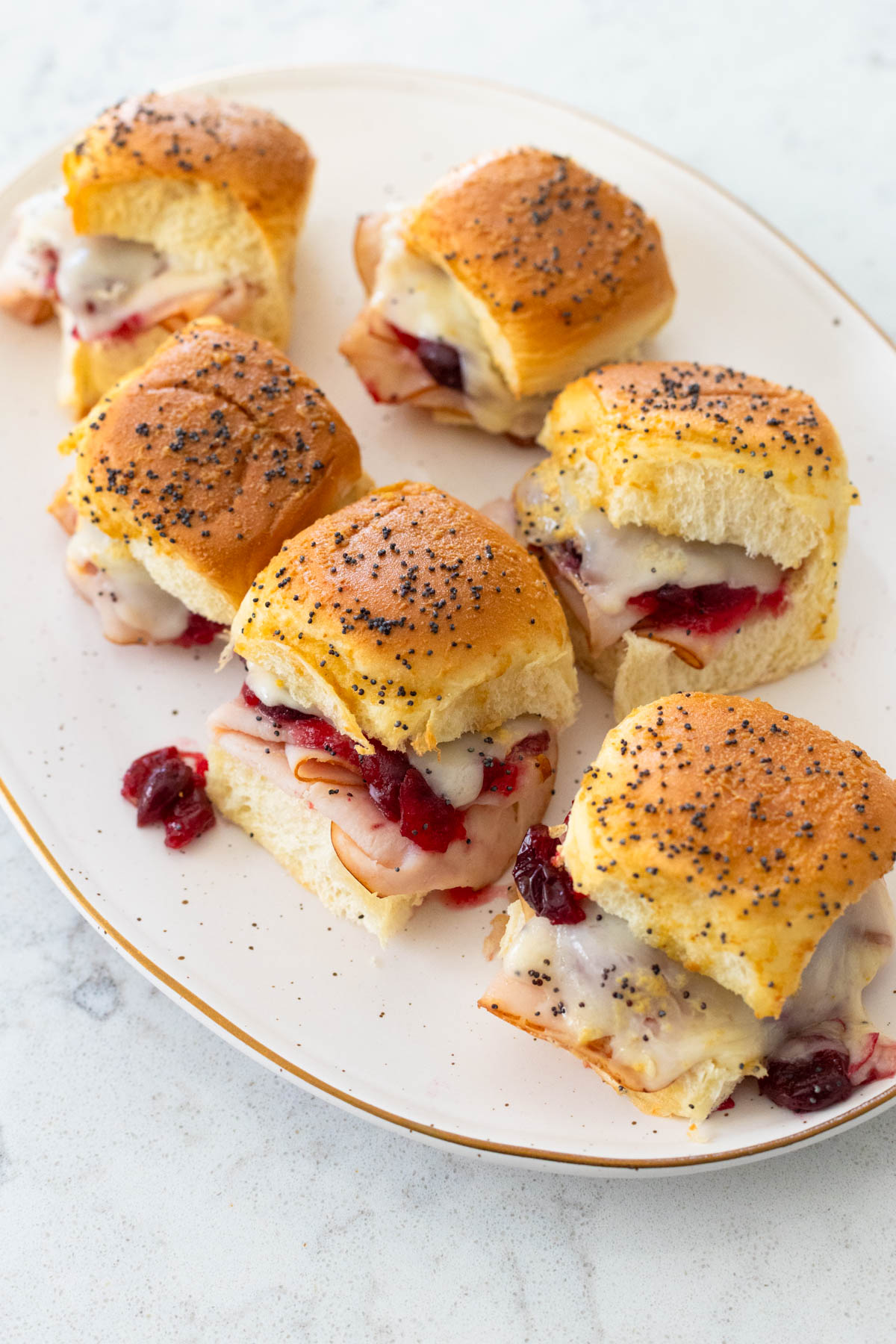 The baked cranberry turkey sliders are served on an oval platter.
