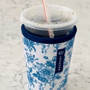 A blue and white toile patterned cozy on a to go cup.