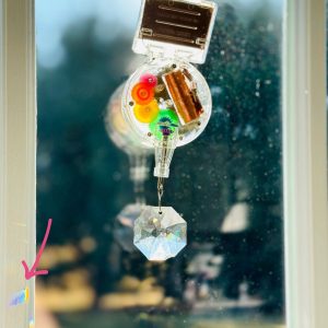 A solar powered crystal rainbow maker that clings to a kitchen window.