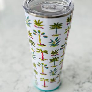 A white coffee cup with palm trees on it.
