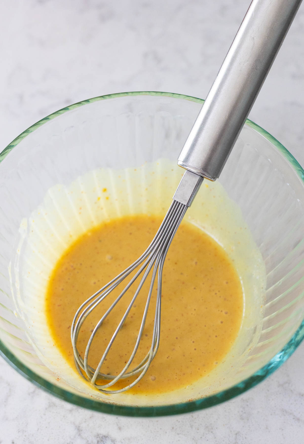 The dip has been whisked together and is a smooth and creamy yellow.
