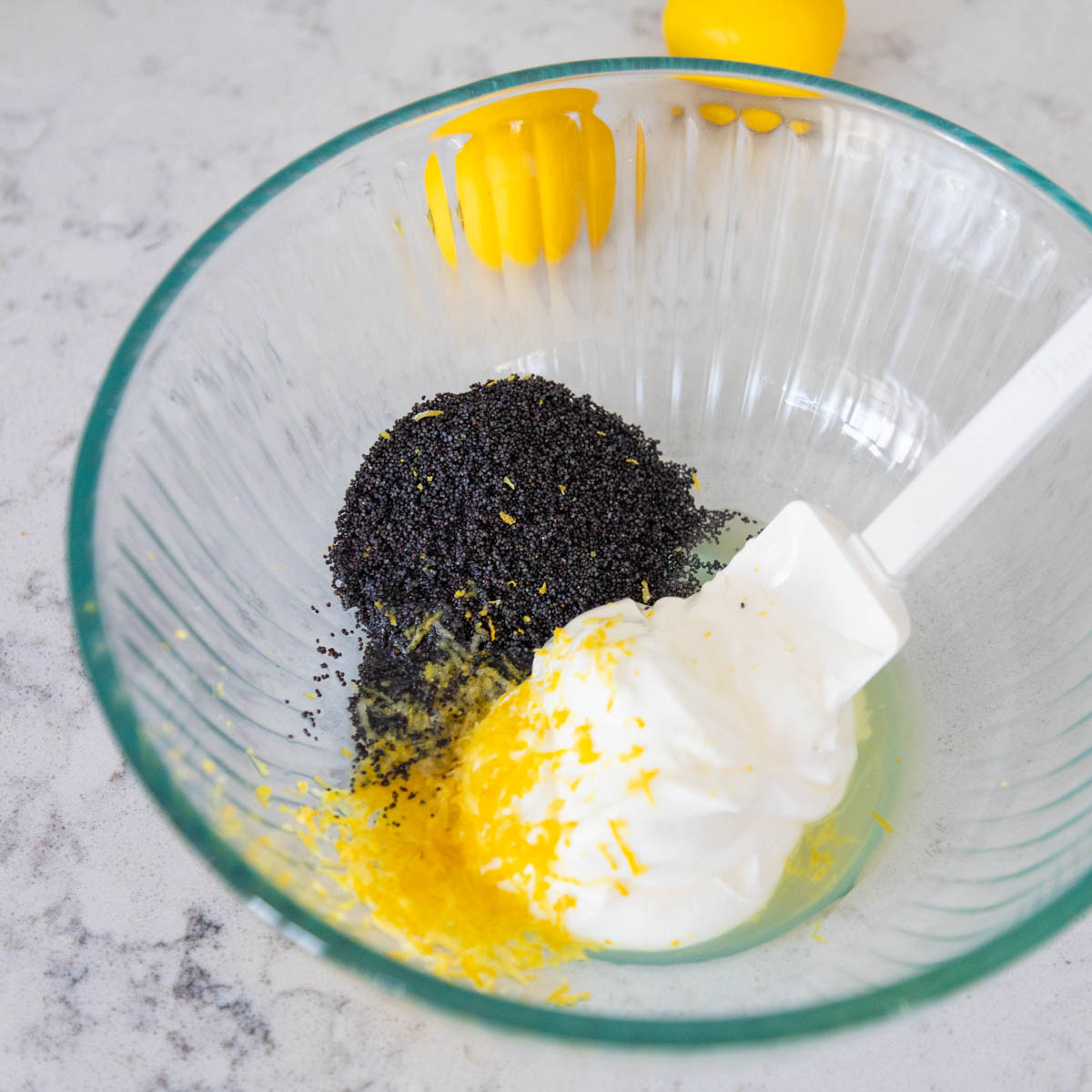 The lemon zest and poppy seeds are mixed into the sour cream in a separate small bowl.