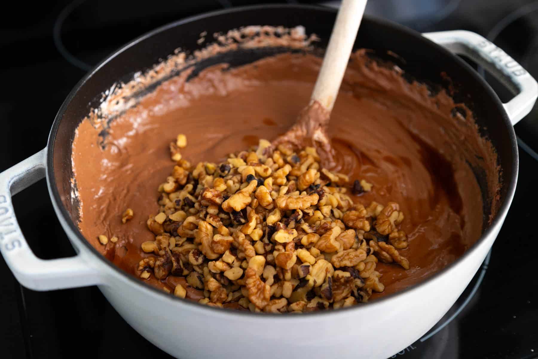 The walnuts are being stirred into the fudge.