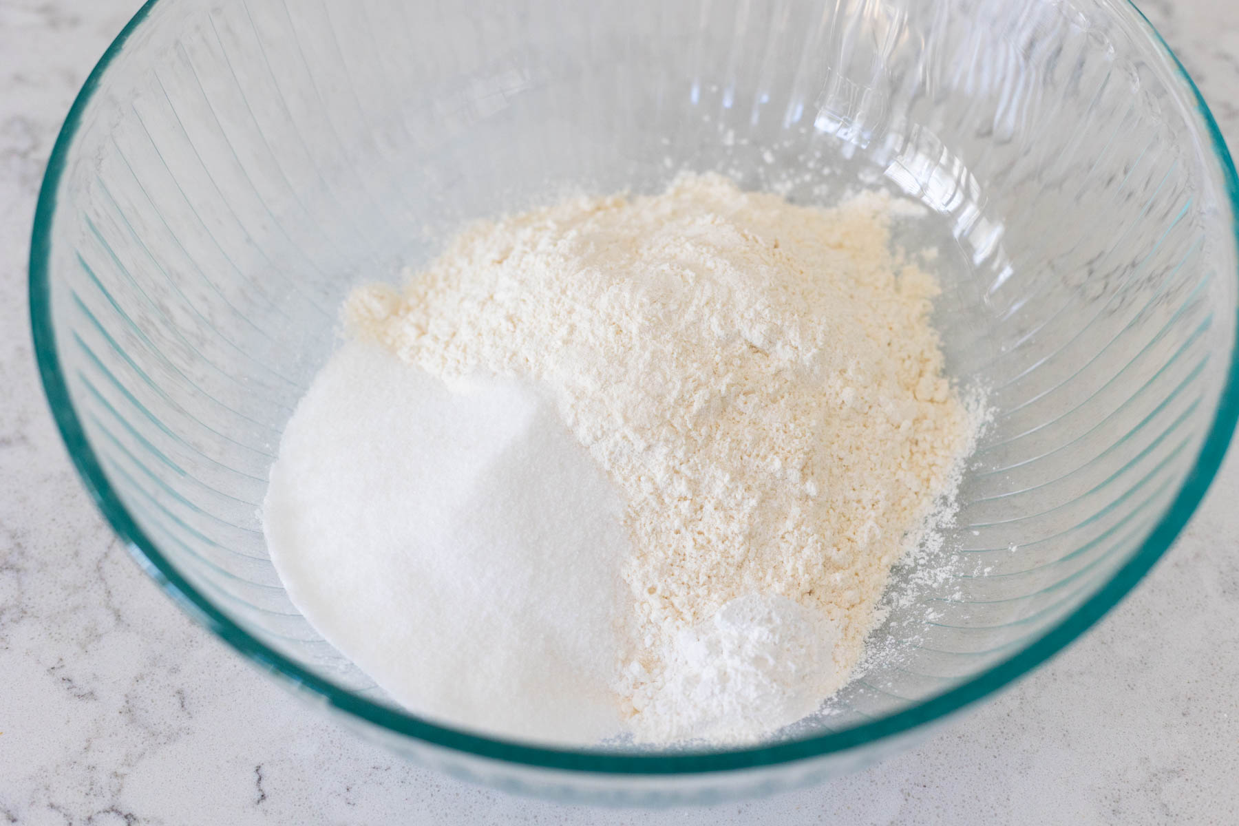 The flour, sugar, and baking powder are in a large mixing bowl.
