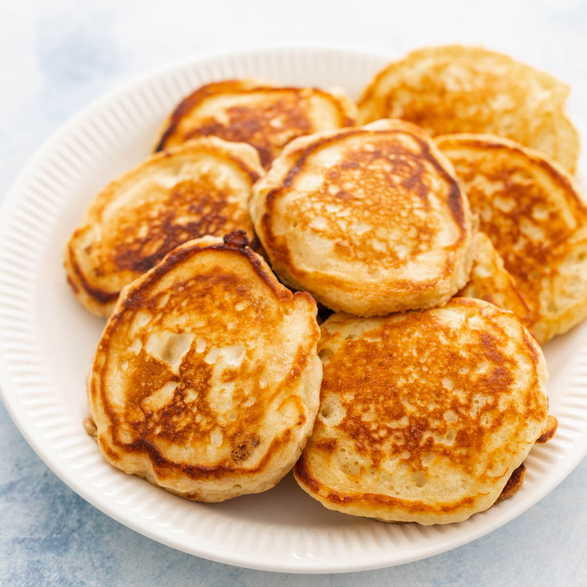 A white plate is filled with homemade buttermilk pancakes.