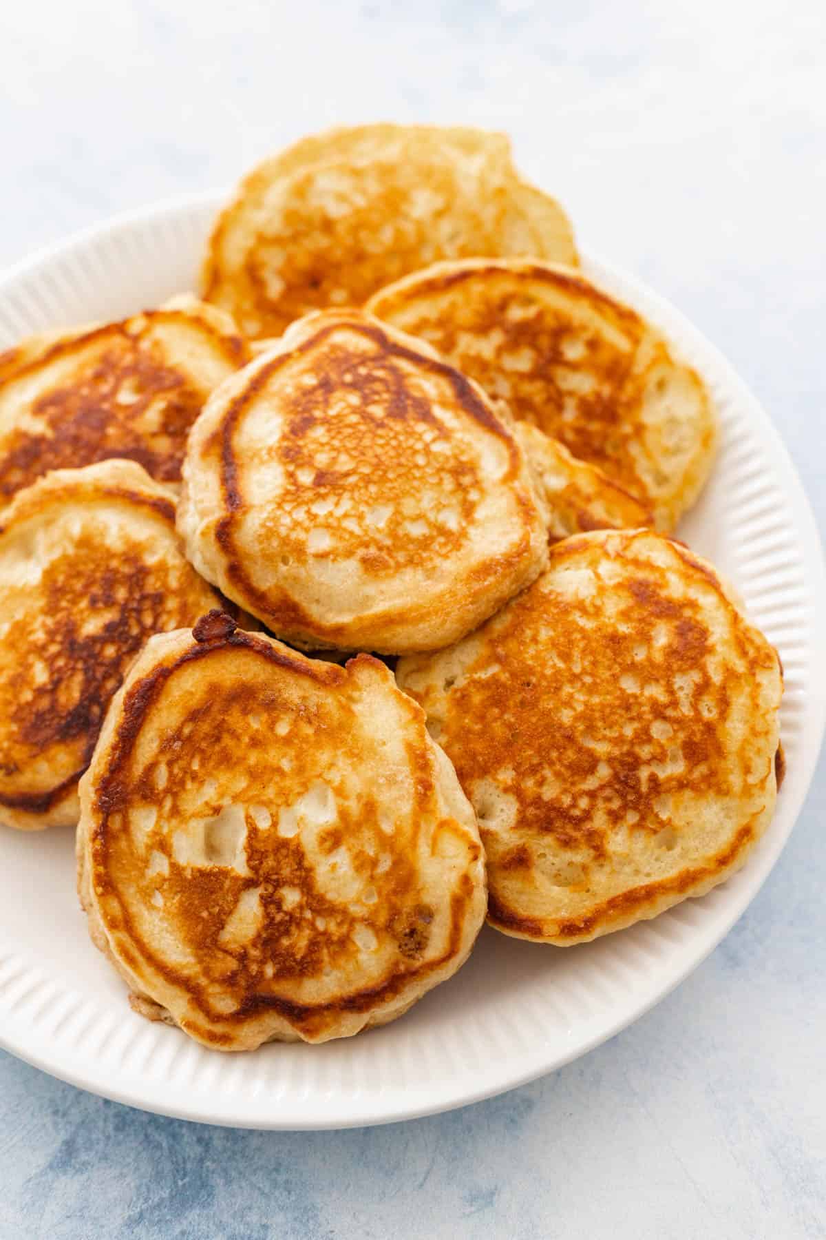 A white plate is filled with homemade buttermilk pancakes.