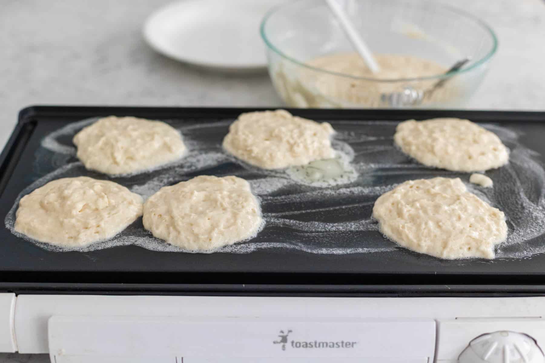 The pancakes have been added to the griddle.