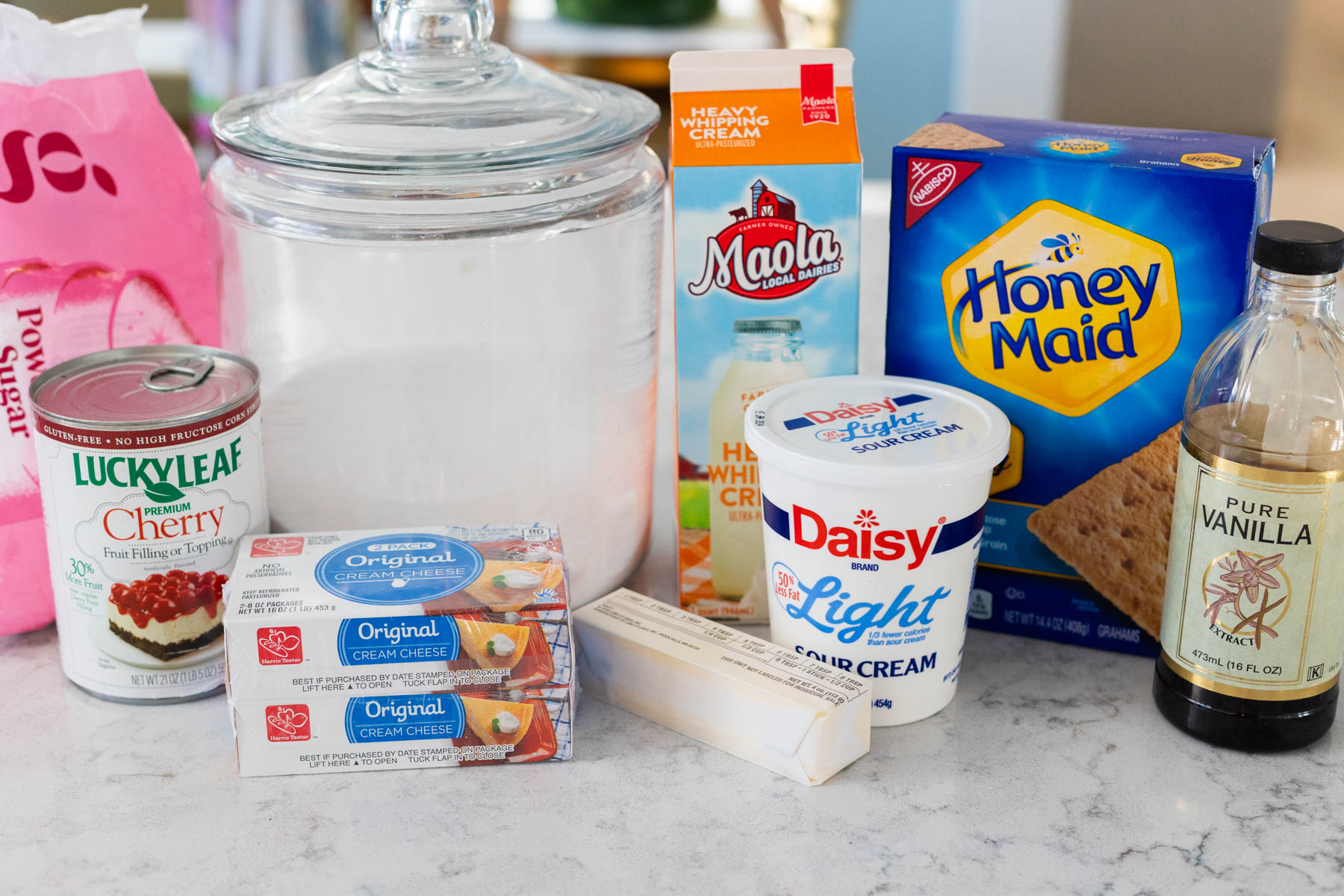 The ingredients to make a homemade cherry delight dessert are on the kitchen counter.