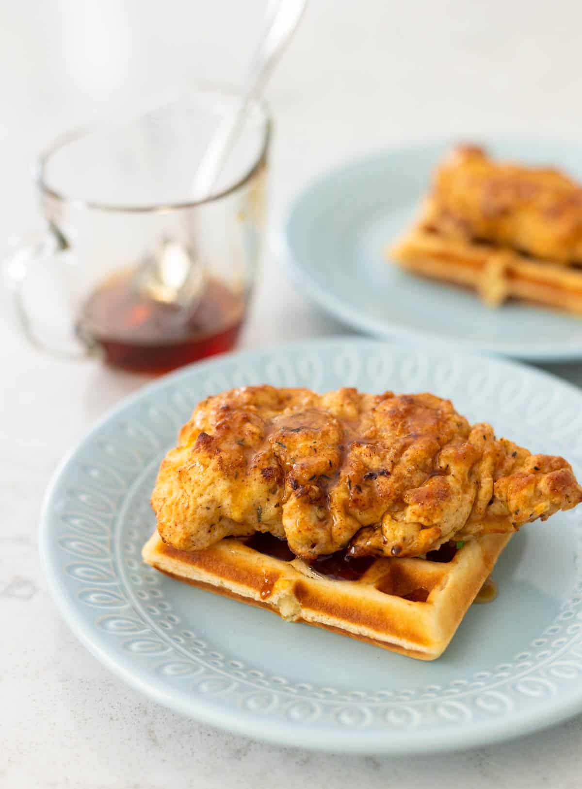 The sauce for the chicken and waffles is served in a pitcher.