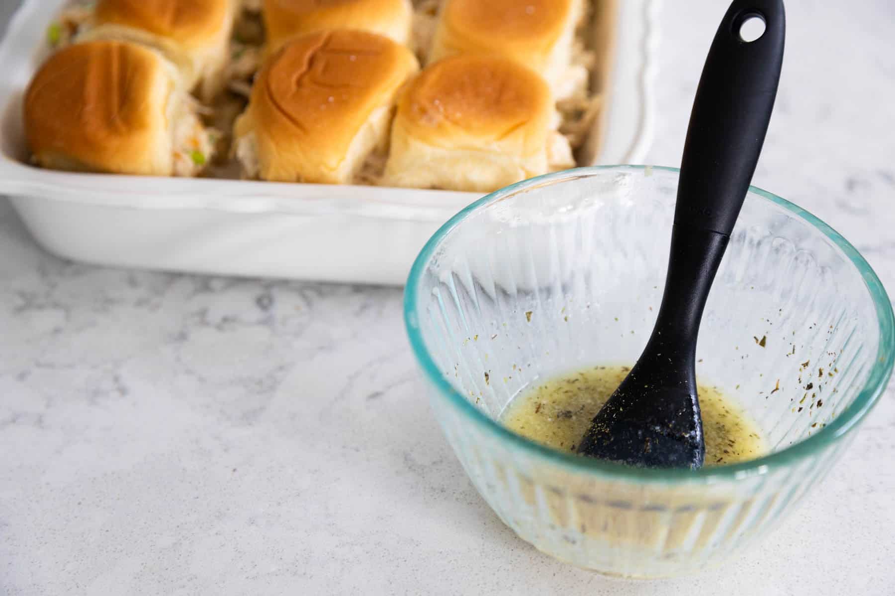 The seasoned butter is in a mixing bowl with a pastry brush.