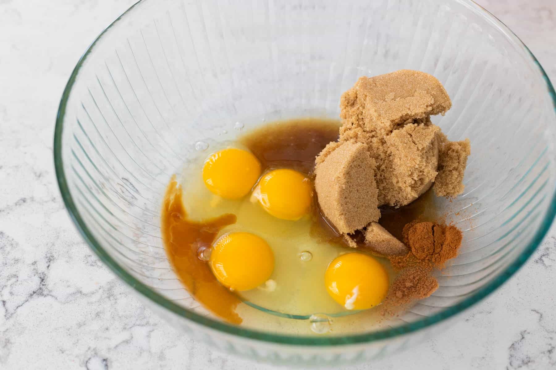 The eggs, brown sugar, bourbon, and other ingredients are in the mixing bowl ready to be whisked together.