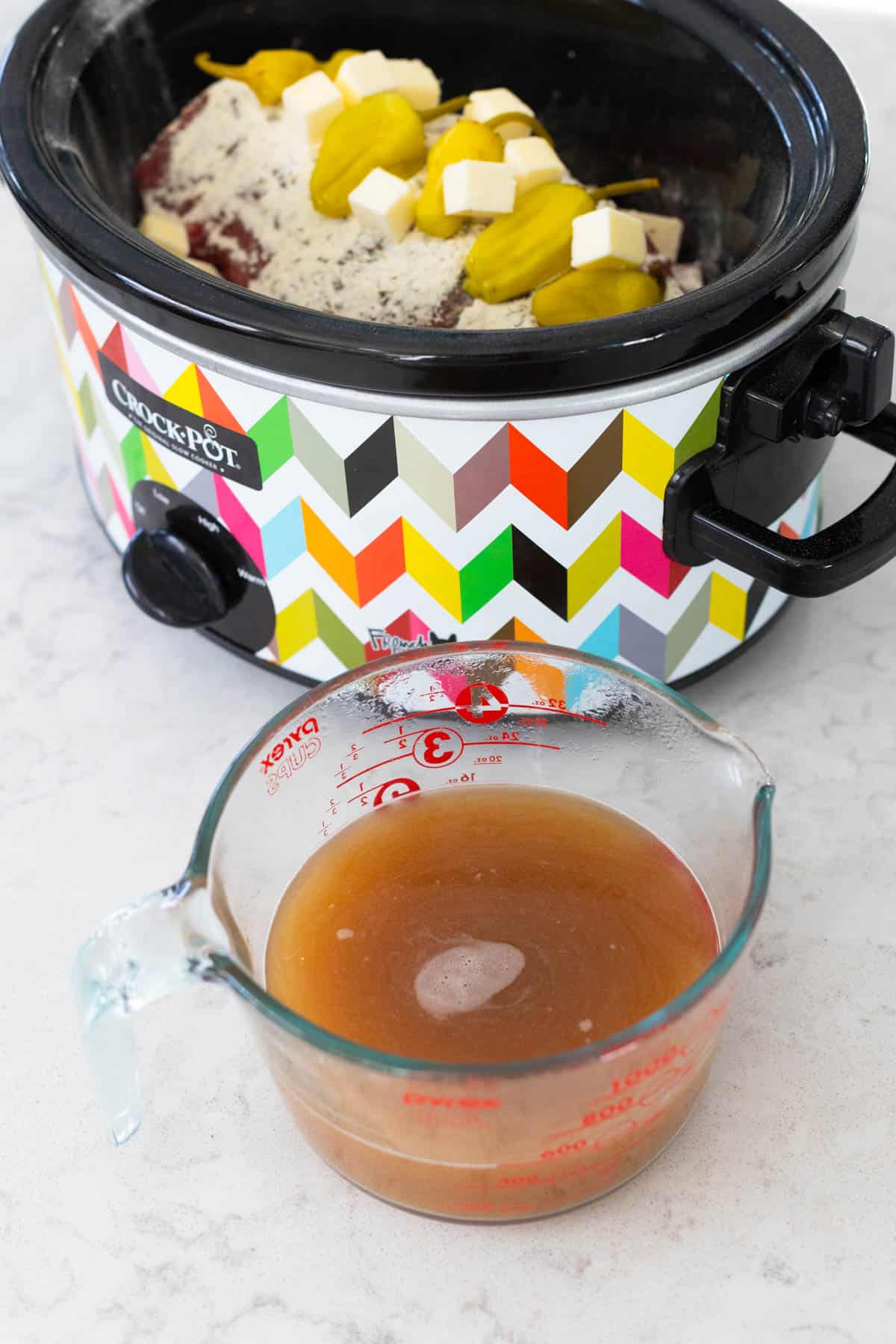 The beef stock has been measured into a liquid measuring cup so the cornstarch can be whisked in.