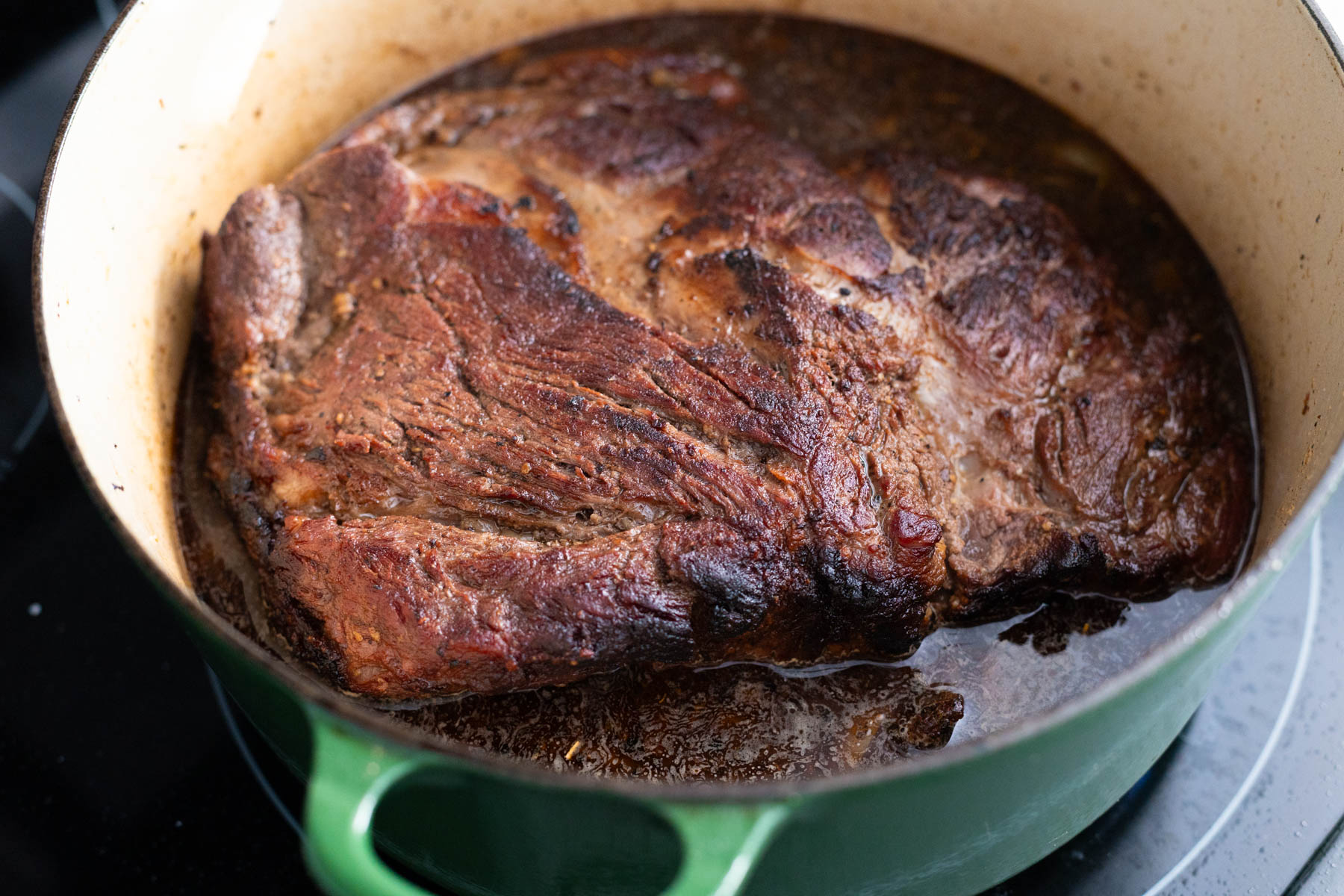 The chuck roast has been seared and is now resting in an inch of beef stock about to be slowcooked in the oven.
