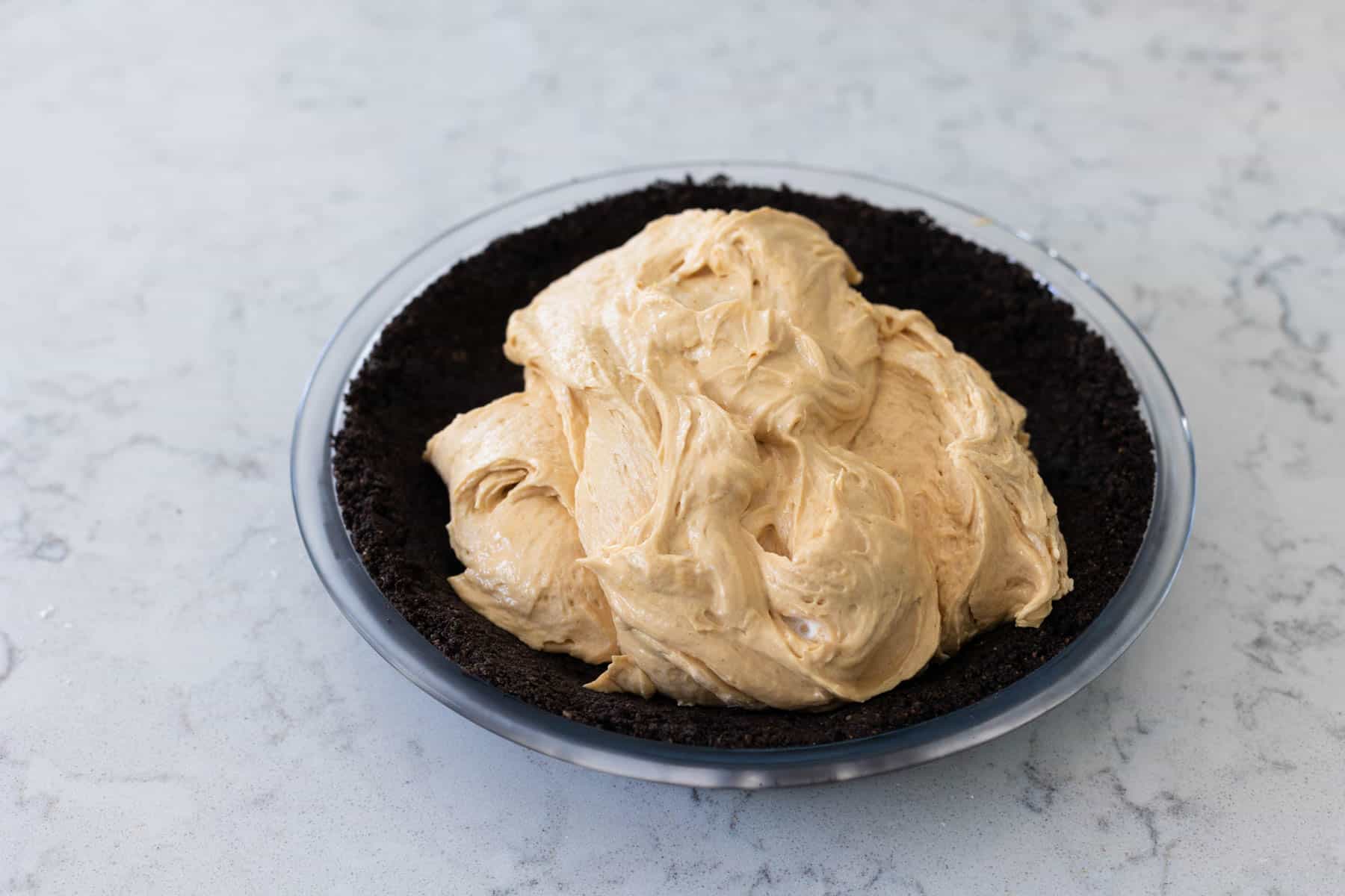 The peanut butter filling is spooned into the pie crust.