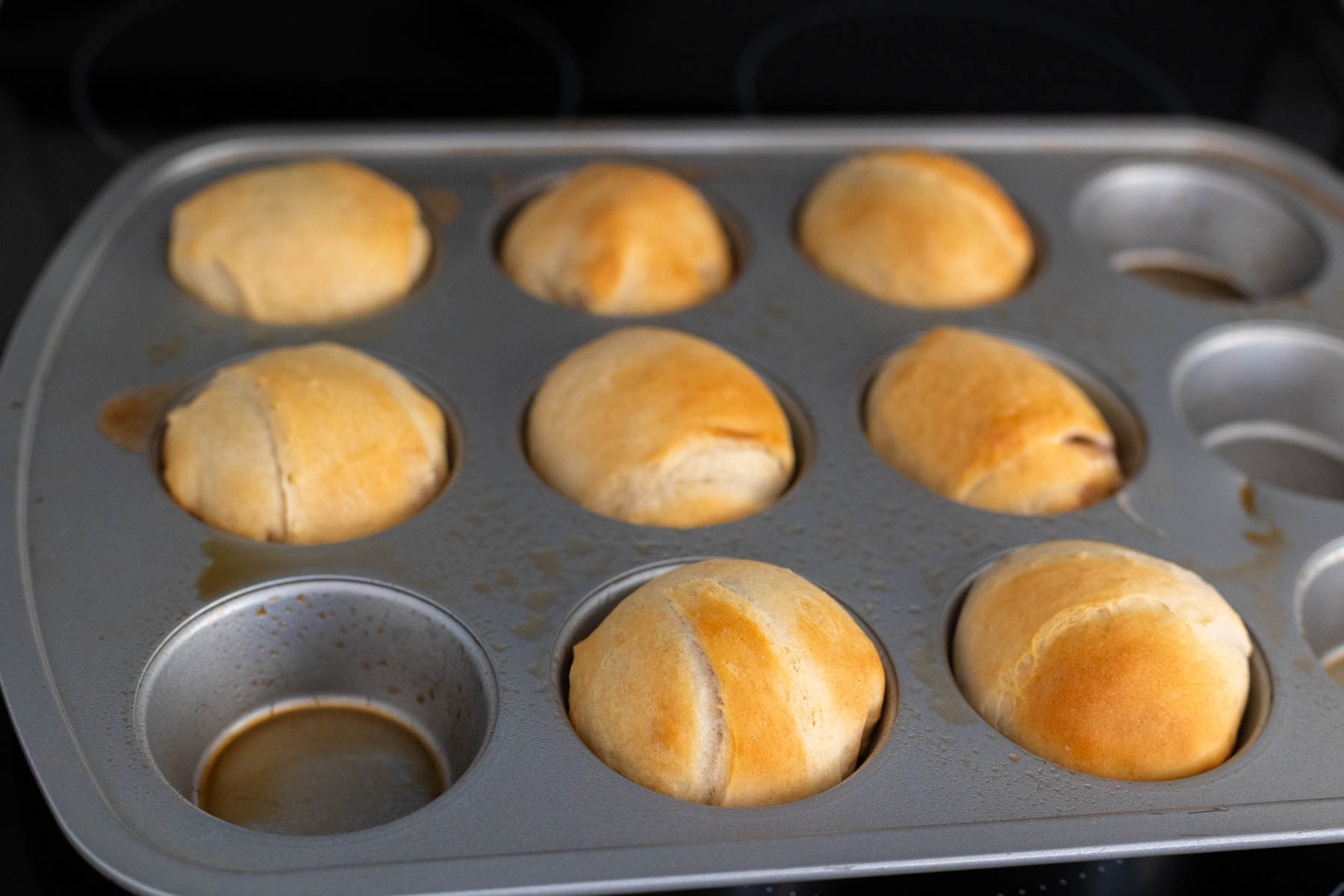 The rolls have been baked in a muffin tin and are a golden brown. 