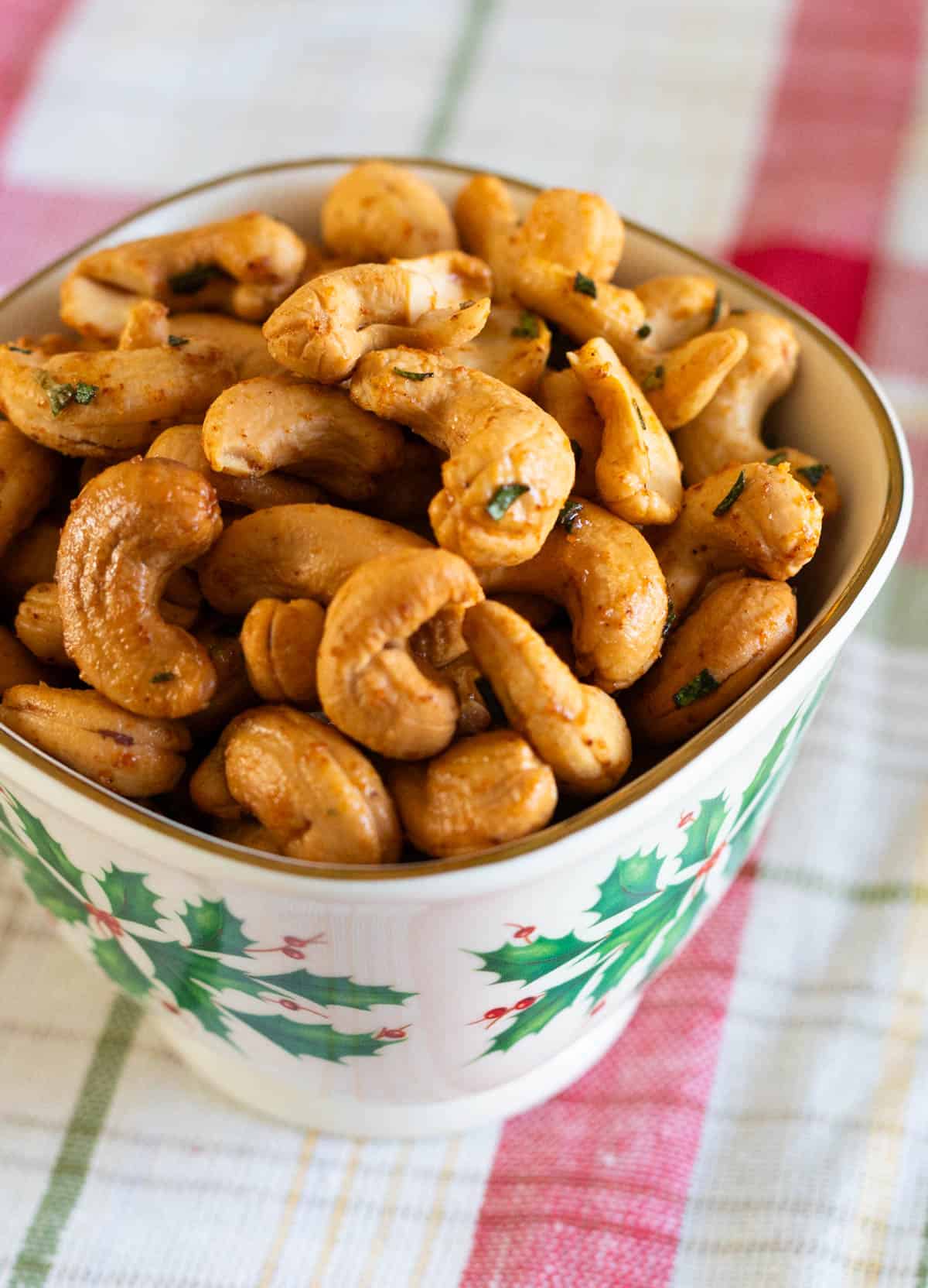 The cashews are in a cute little holiday nut bowl on a red plaid table cloth.