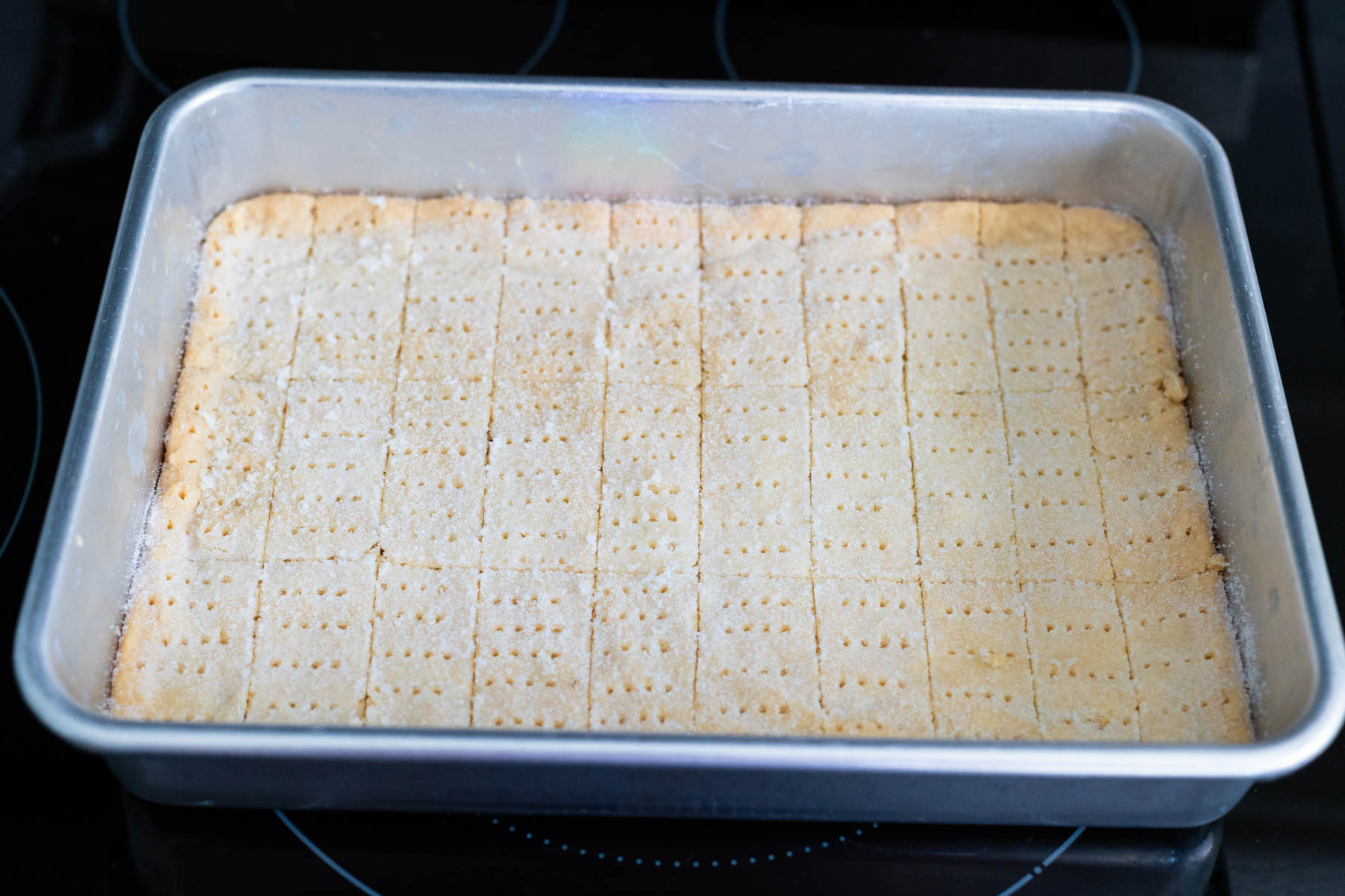 The pan of shortbread has been neatly pricked with a fork to make a pretty pattern.