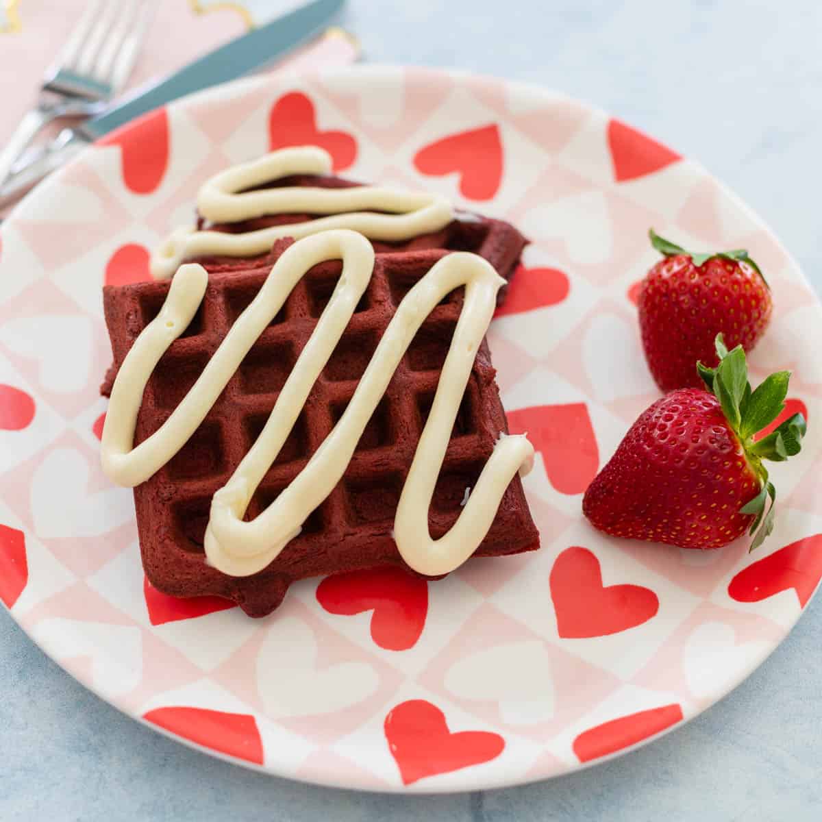 Red velvet waffles on a pink and red heart plate.