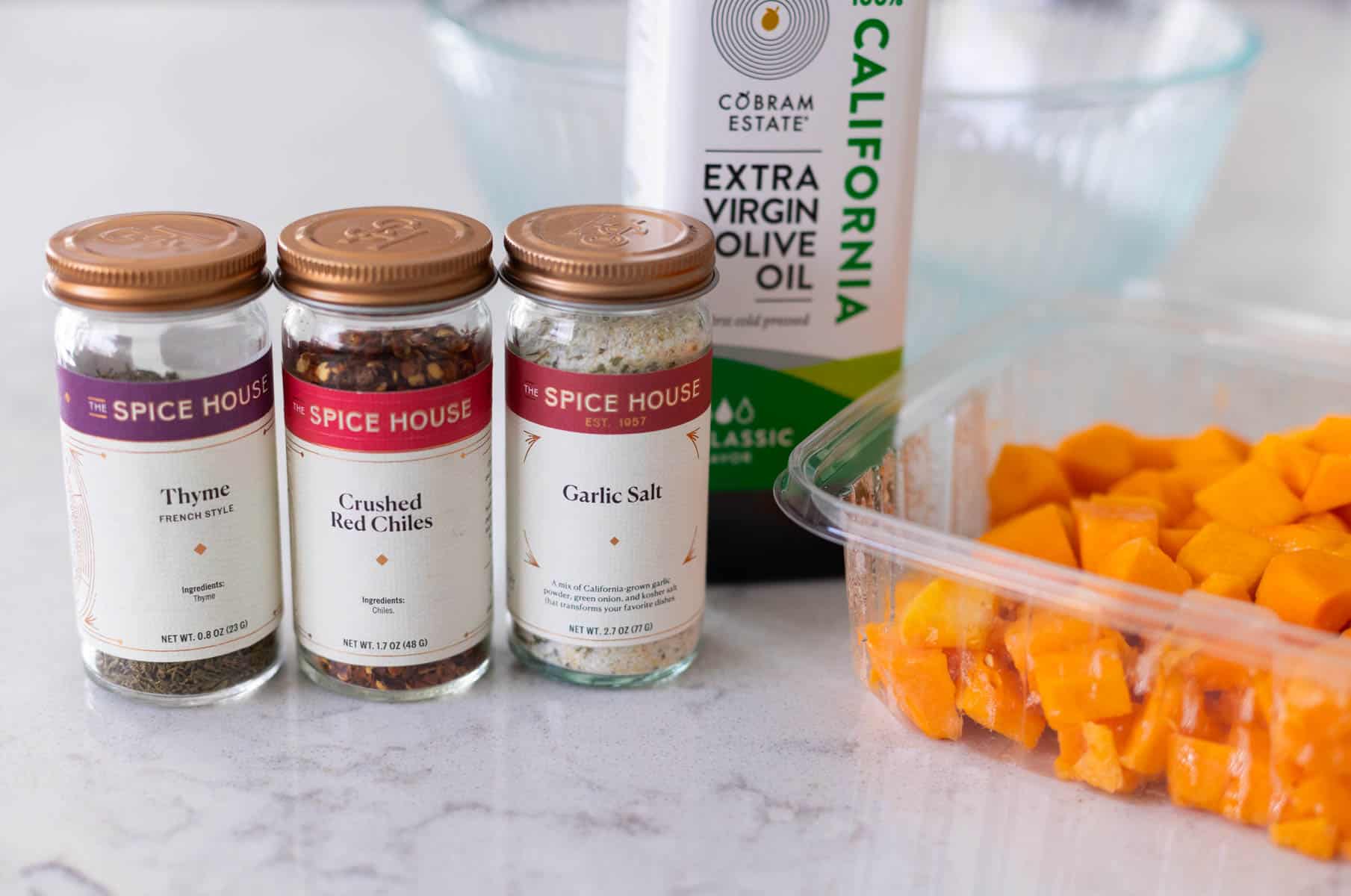 The ingredients to make butternut squash in the air fryer are on the counter.