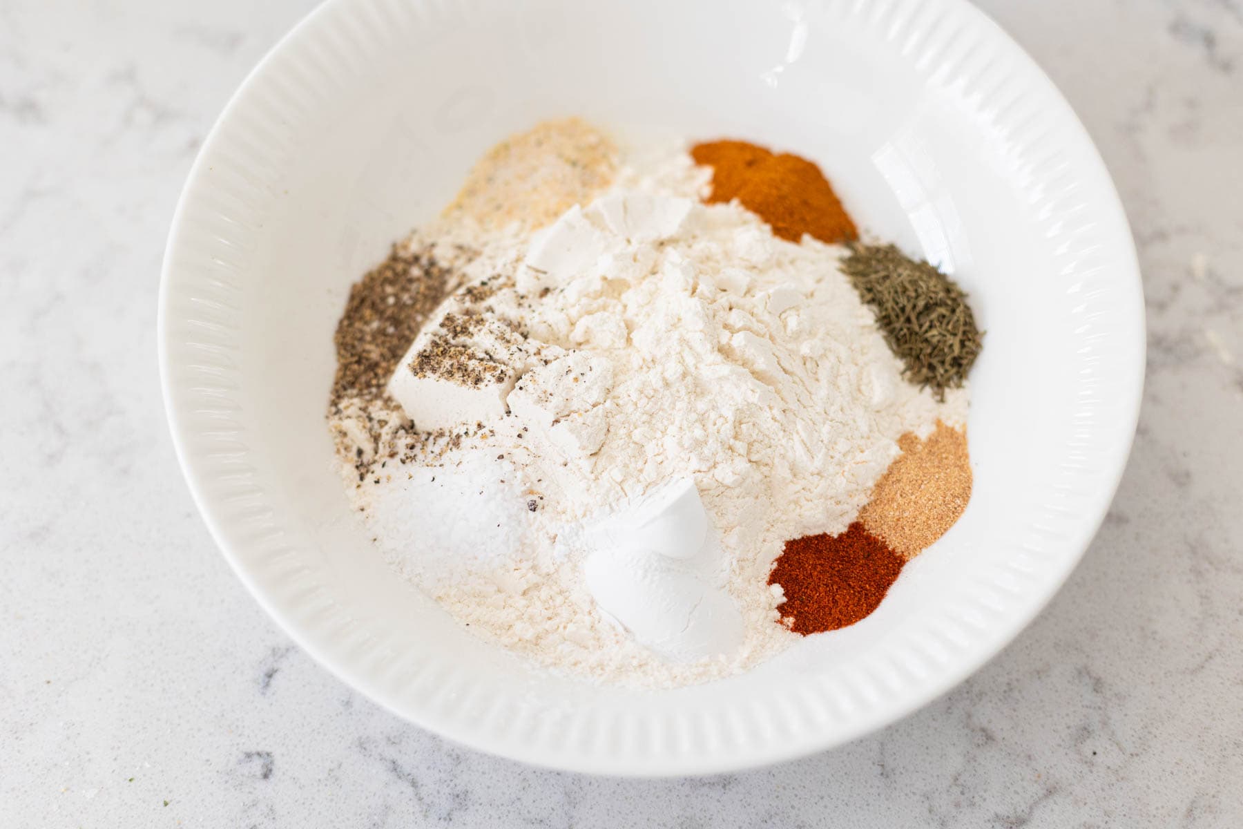 The seasonings and flour are in a mixing bowl.