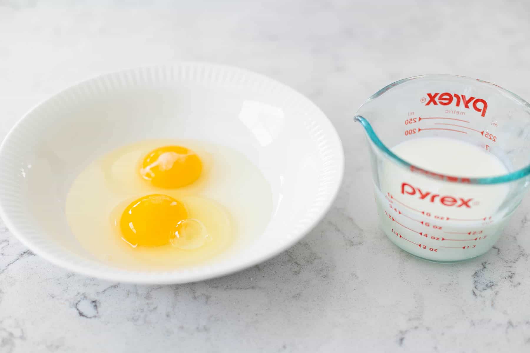 The eggs are in a separate mixing bowl, the buttermilk is about to be poured in.