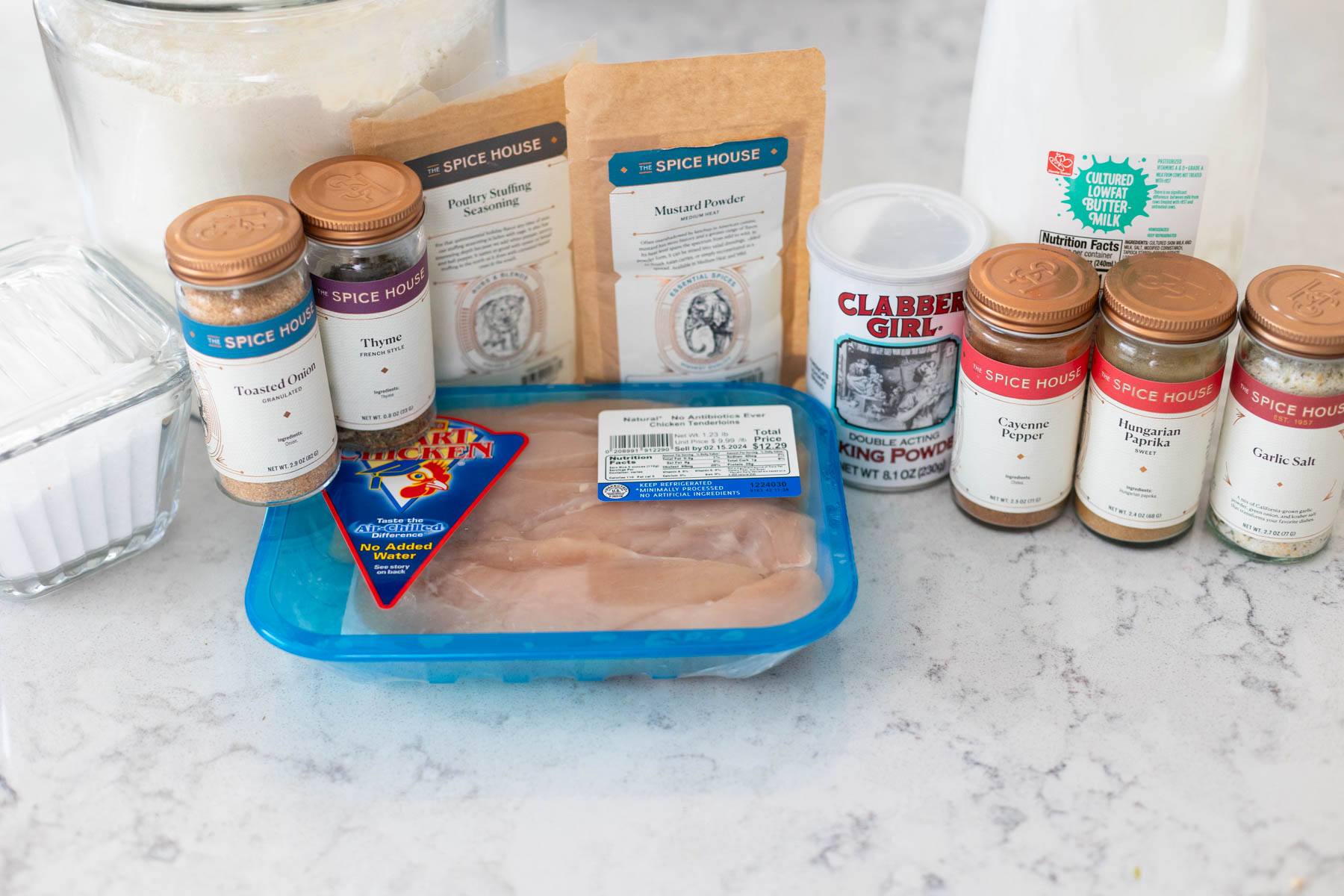 The ingredients to make homemade buttermilk fried chicken in the oven are on the counter.