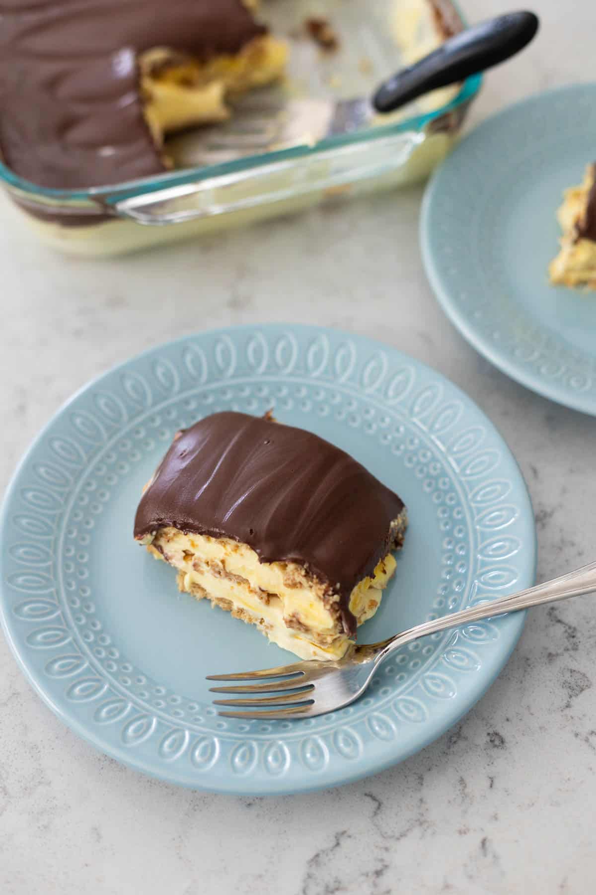 A serving of chocolate eclair cake on a blue plate.