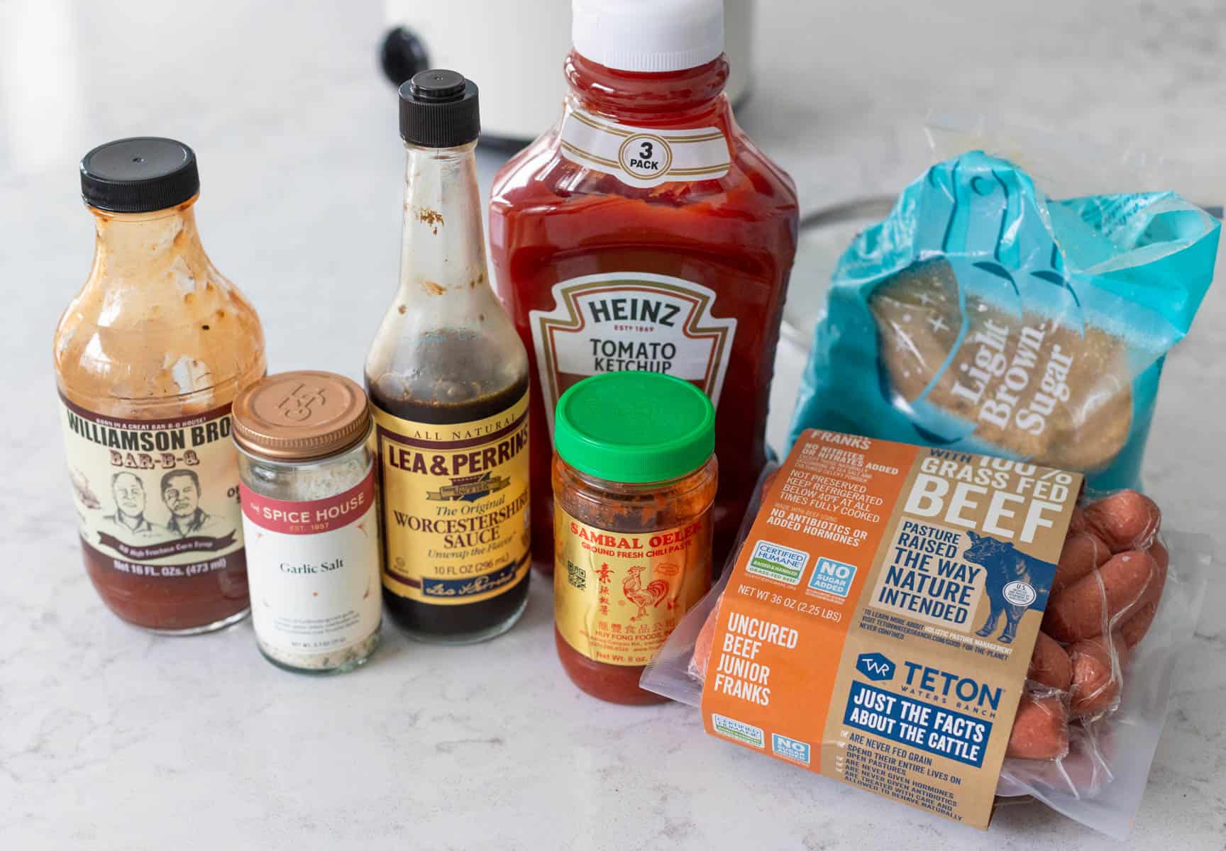 The ingredients to make barbecue little smokies sausages in a slowcooker are on the counter.