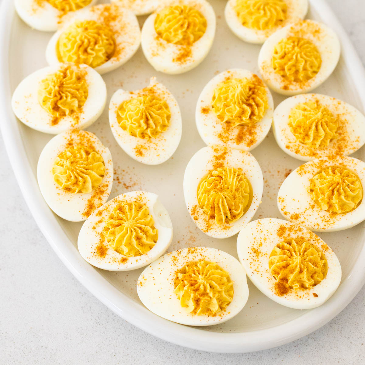 The deviled eggs have been sprinkled with paprika on top.