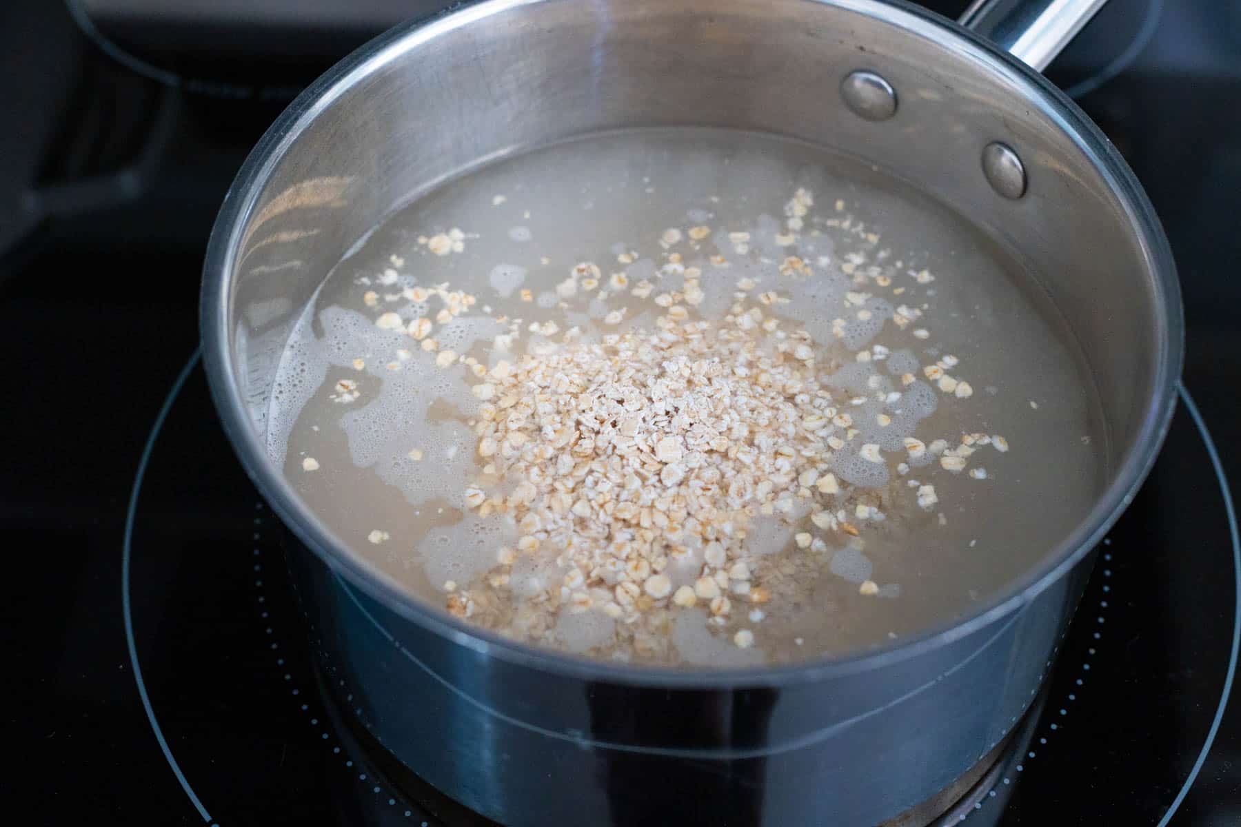 The oatmeal and water are in a pot on the stove.