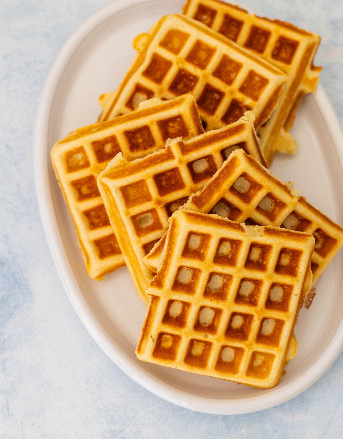 The malted waffles are on a white platter.