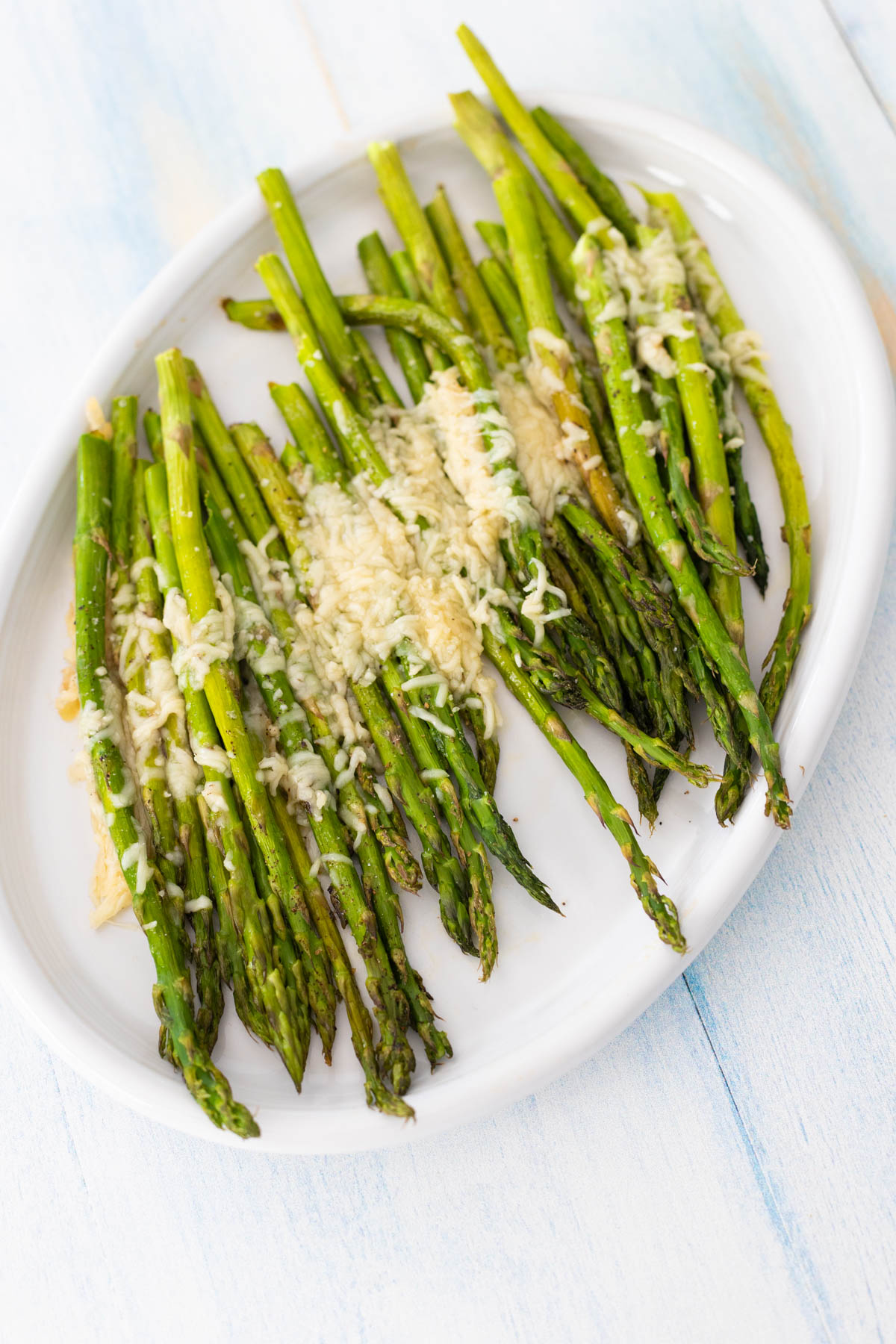 The asparagus is served on a white platter.