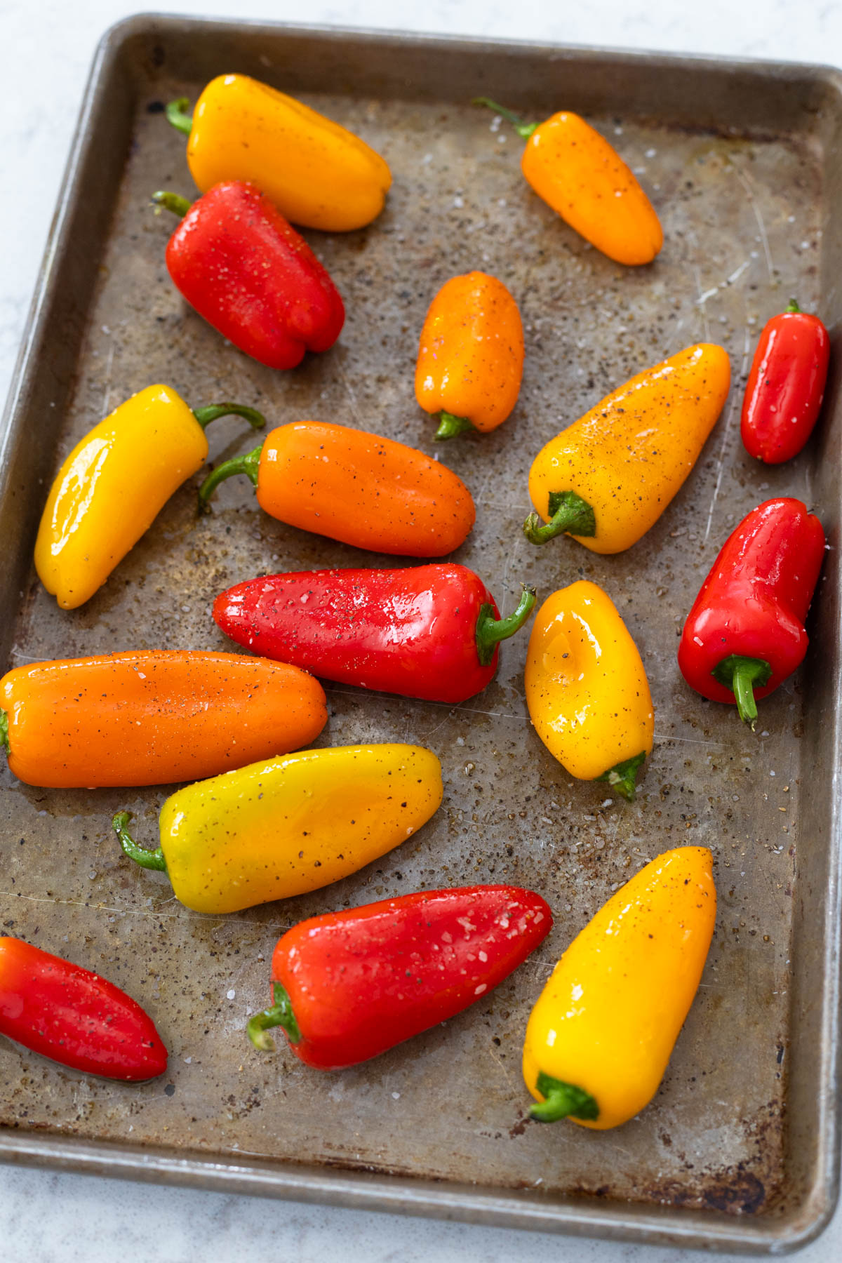 The mini peppers have been tossed in olive oil and sprinkled with salt and pepper.