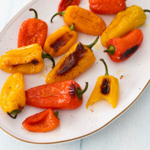 A platter of charred roasted mini peppers.