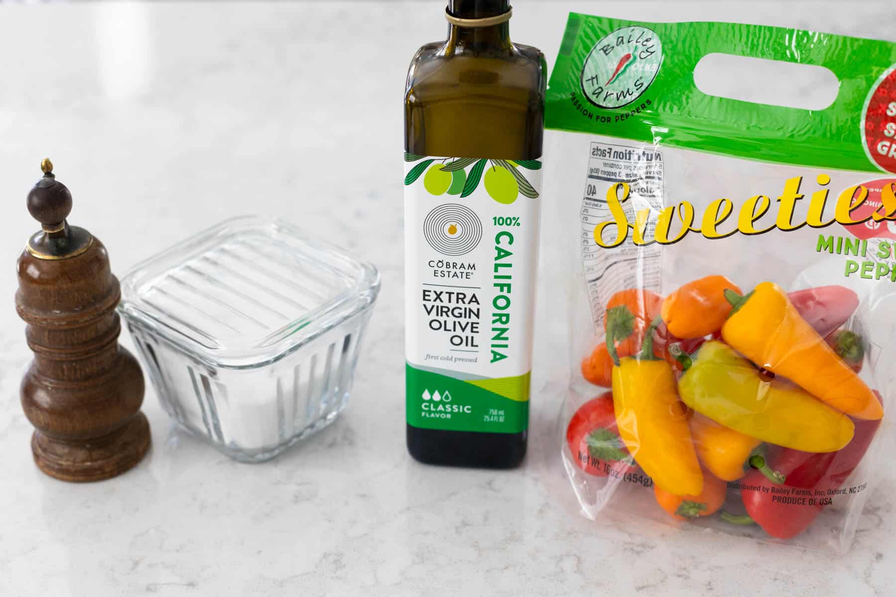 The ingredients to make roasted mini peppers are on the counter.