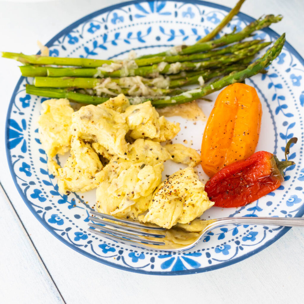 A plate of scrambled eggs with vegetables.