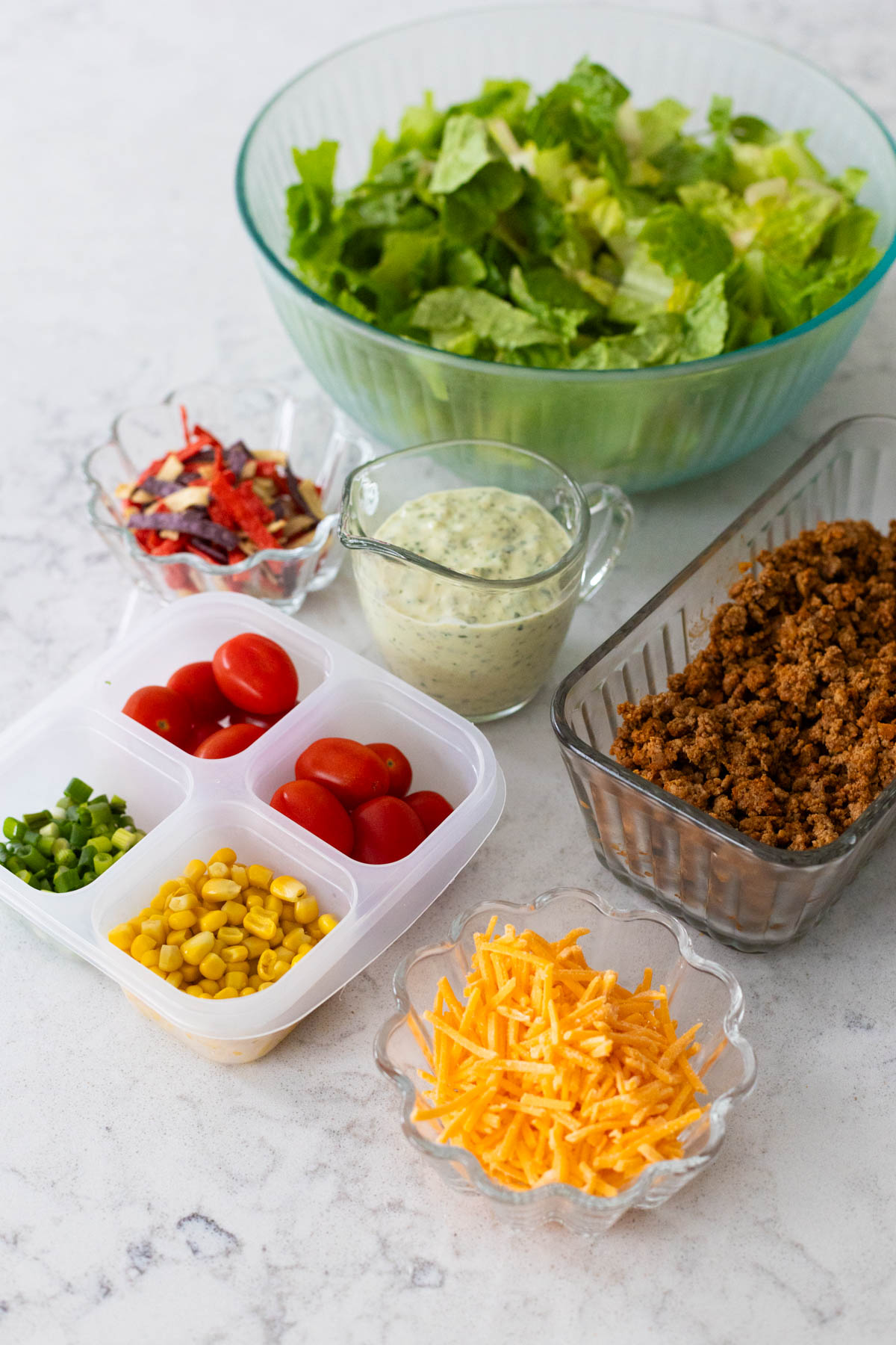 The ingredients to assemble a taco salad are on the counter.
