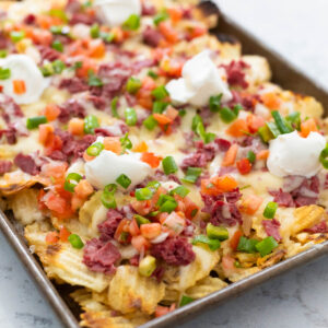 A pan of Irish nachos made with potato chips and corned beef.