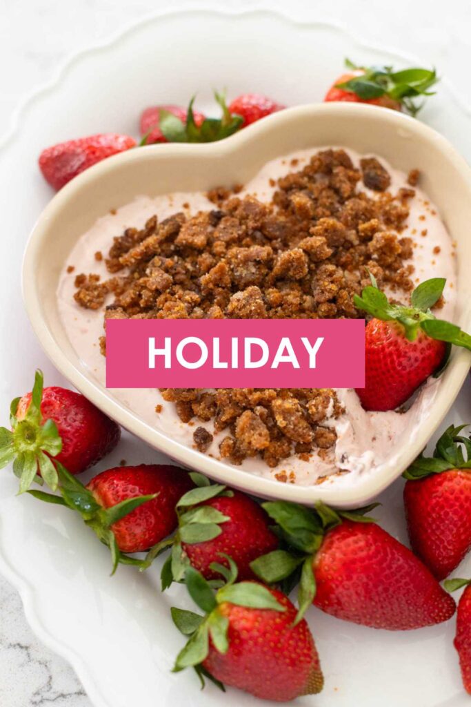 A dish of dip with strawberries says "Holiday" on it.