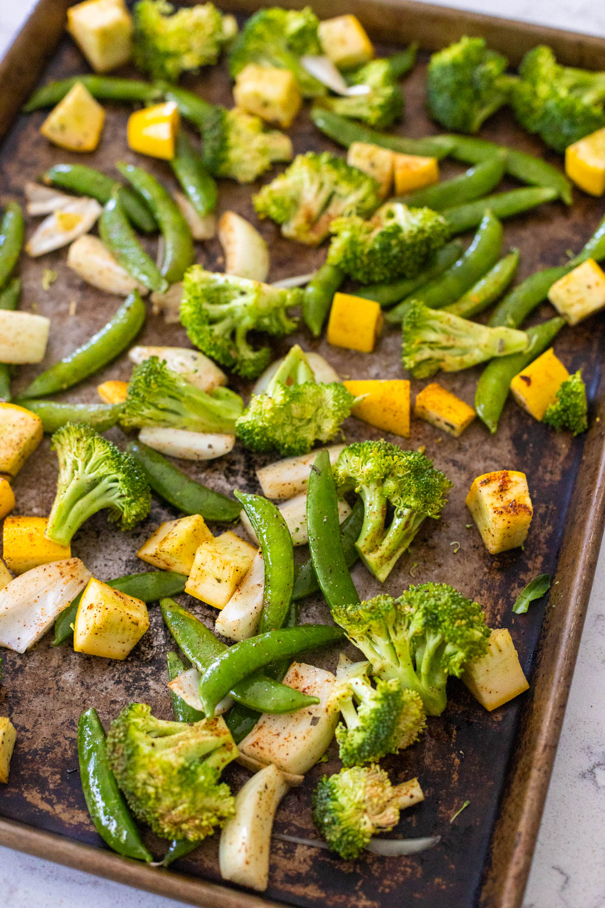 A sheet pan is filled with the seasoned veggies.