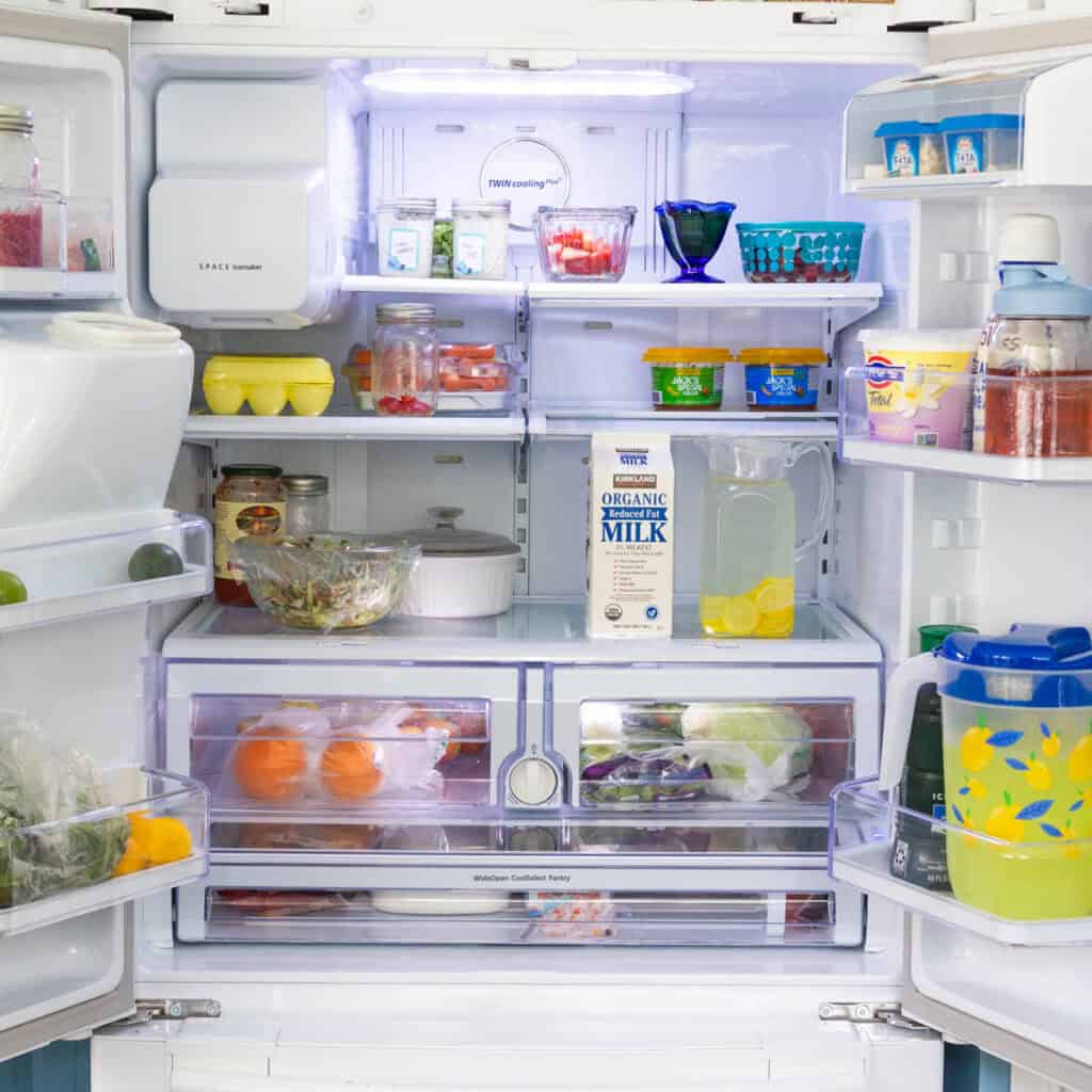 The inside of a regular family refrigerator shows fresh fruits and vegetables, milk, and other staples.