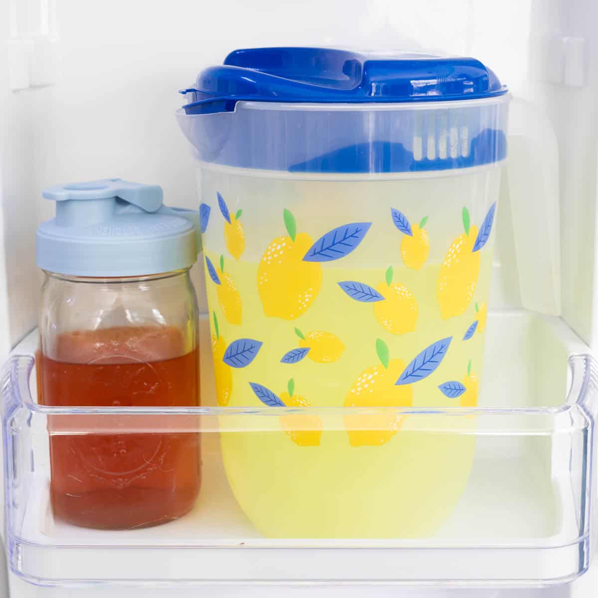 A pitcher of lemonade next to a pitcher of tea.