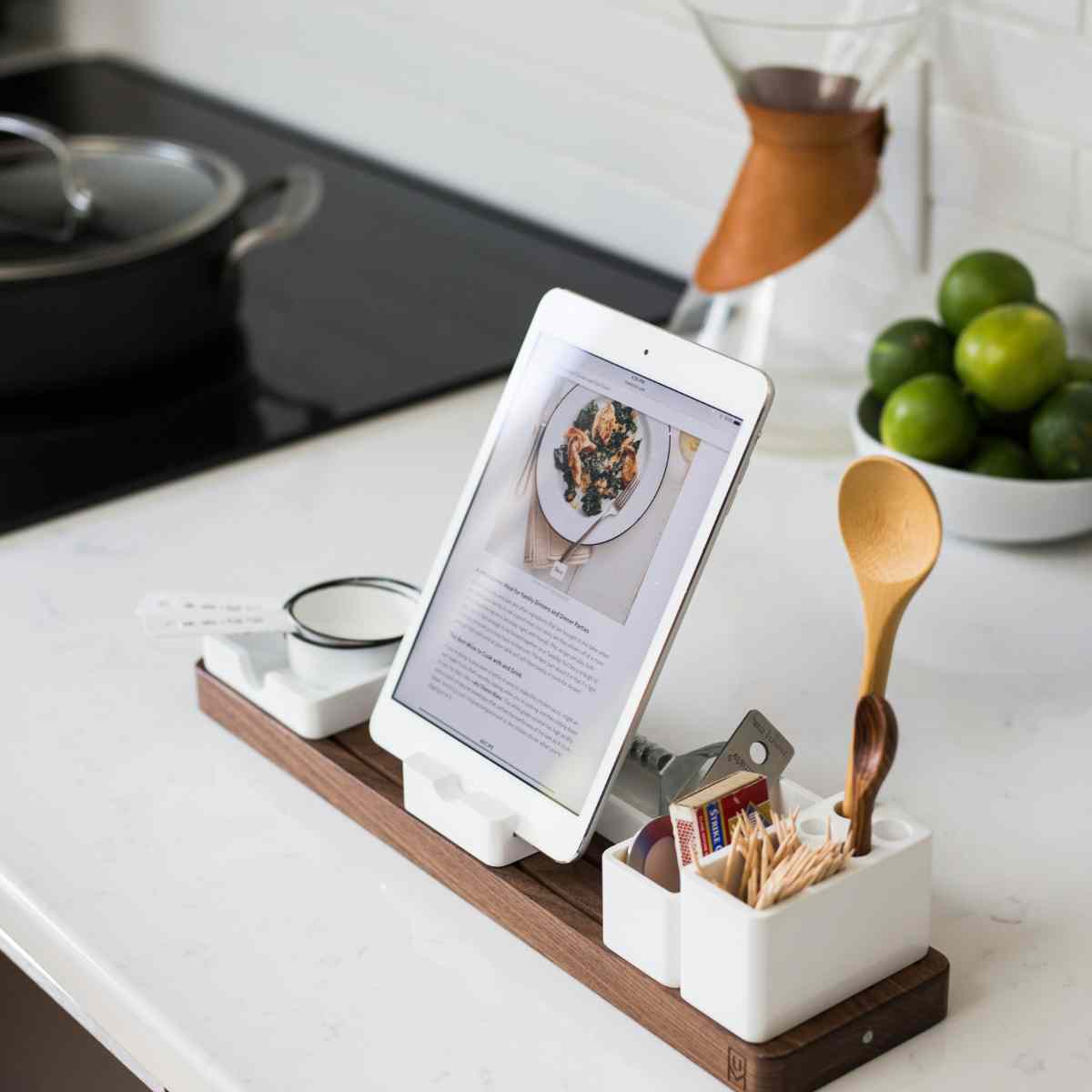 An ipad on the kitchen counter is ready for cooking.