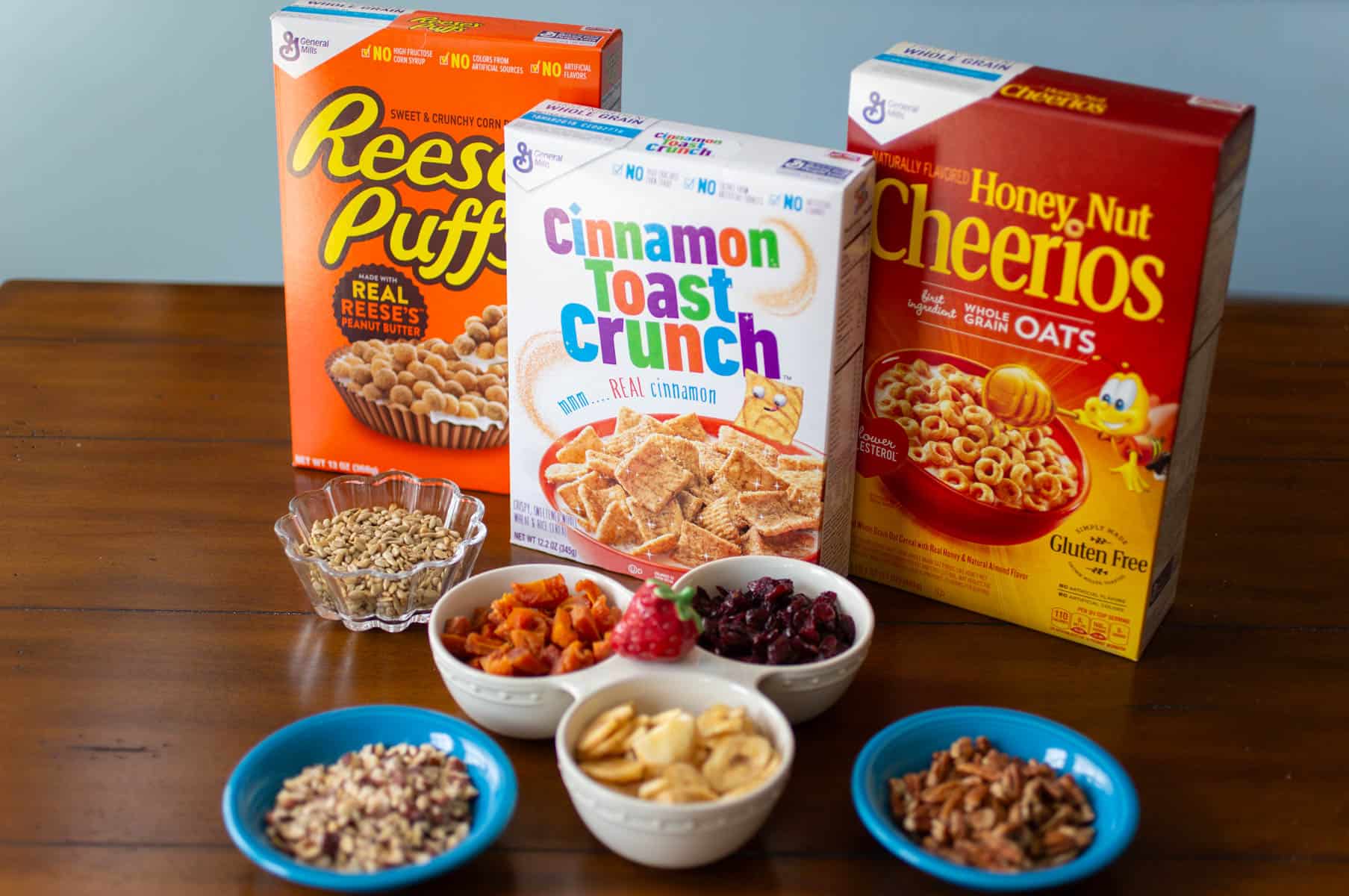The packages of cereal and dried fruit and nuts are ready to be mixed together.