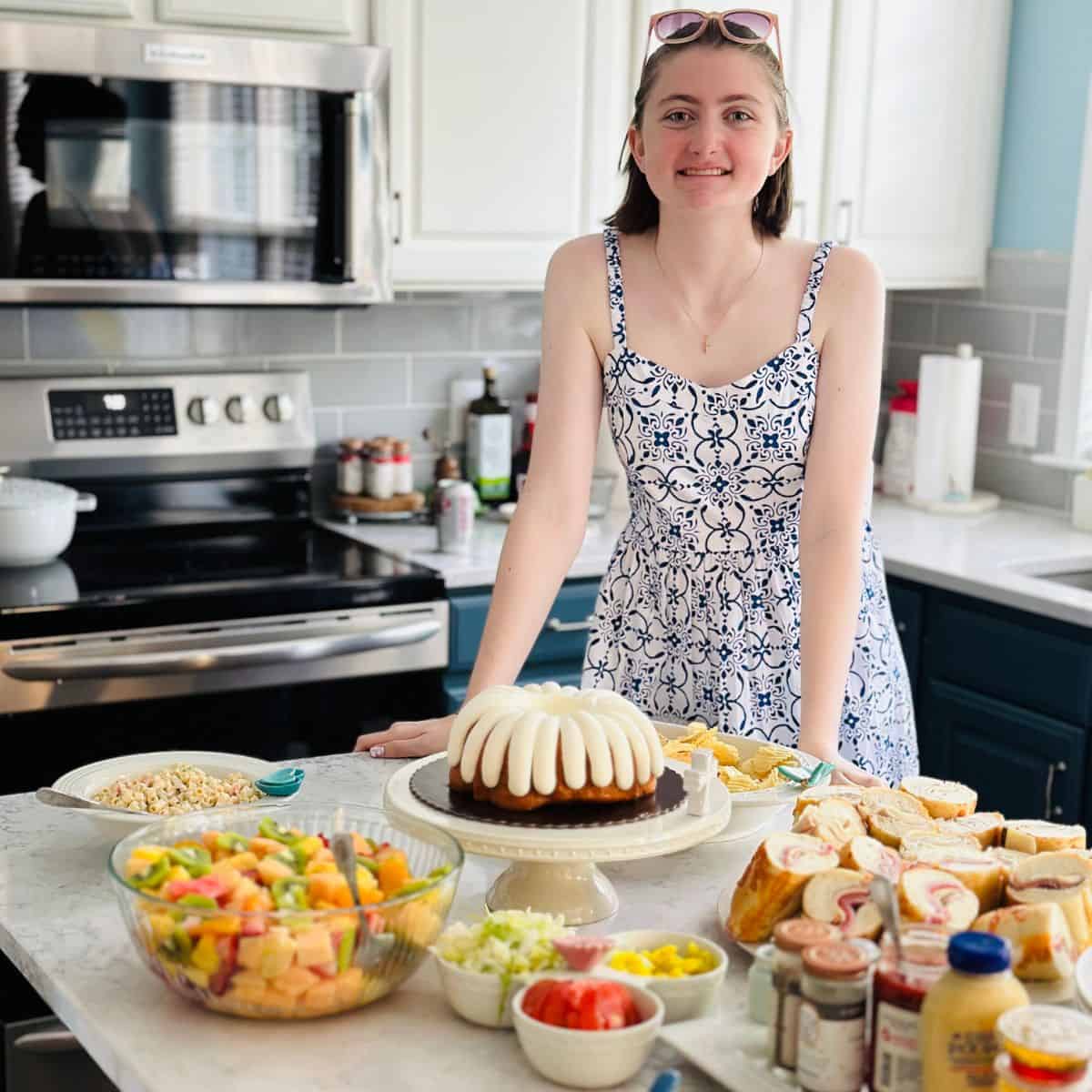 A young girl stands in front of her buffet. 