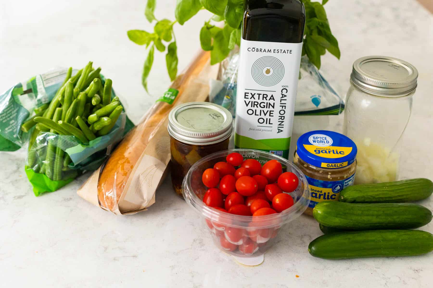 The vegetables and oil are on the counter.