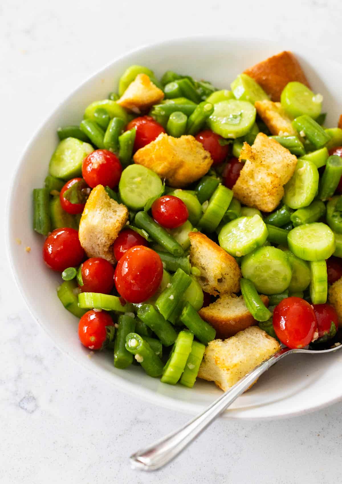 The final salad is in a white serving bowl with a spoon.