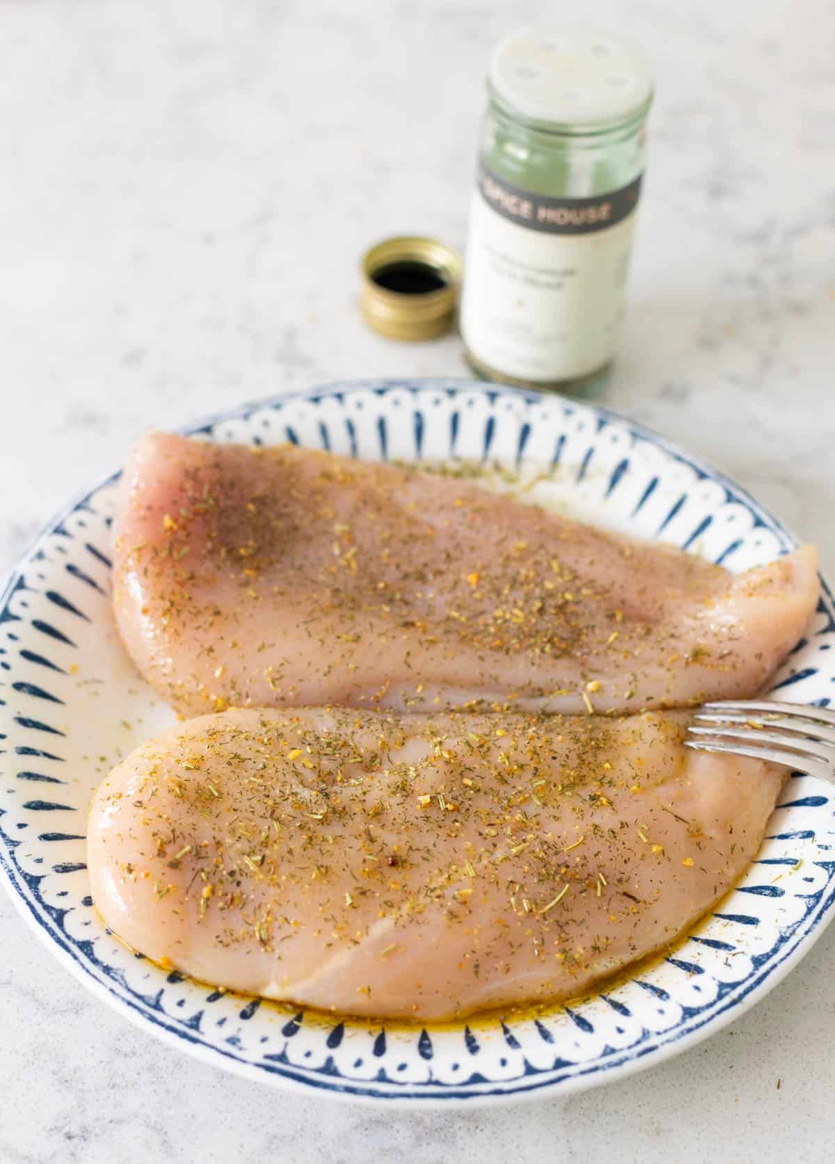 The chicken and seasoning are on the counter. 