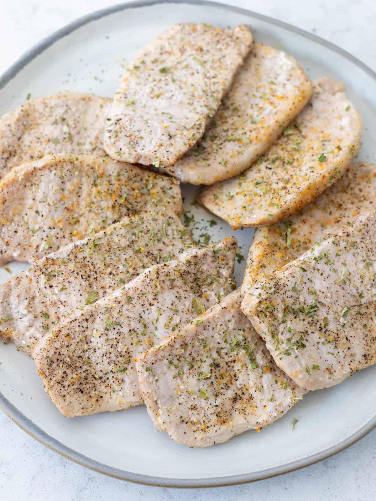 The cooked pork chops have been arranged on a platter to be served family style.