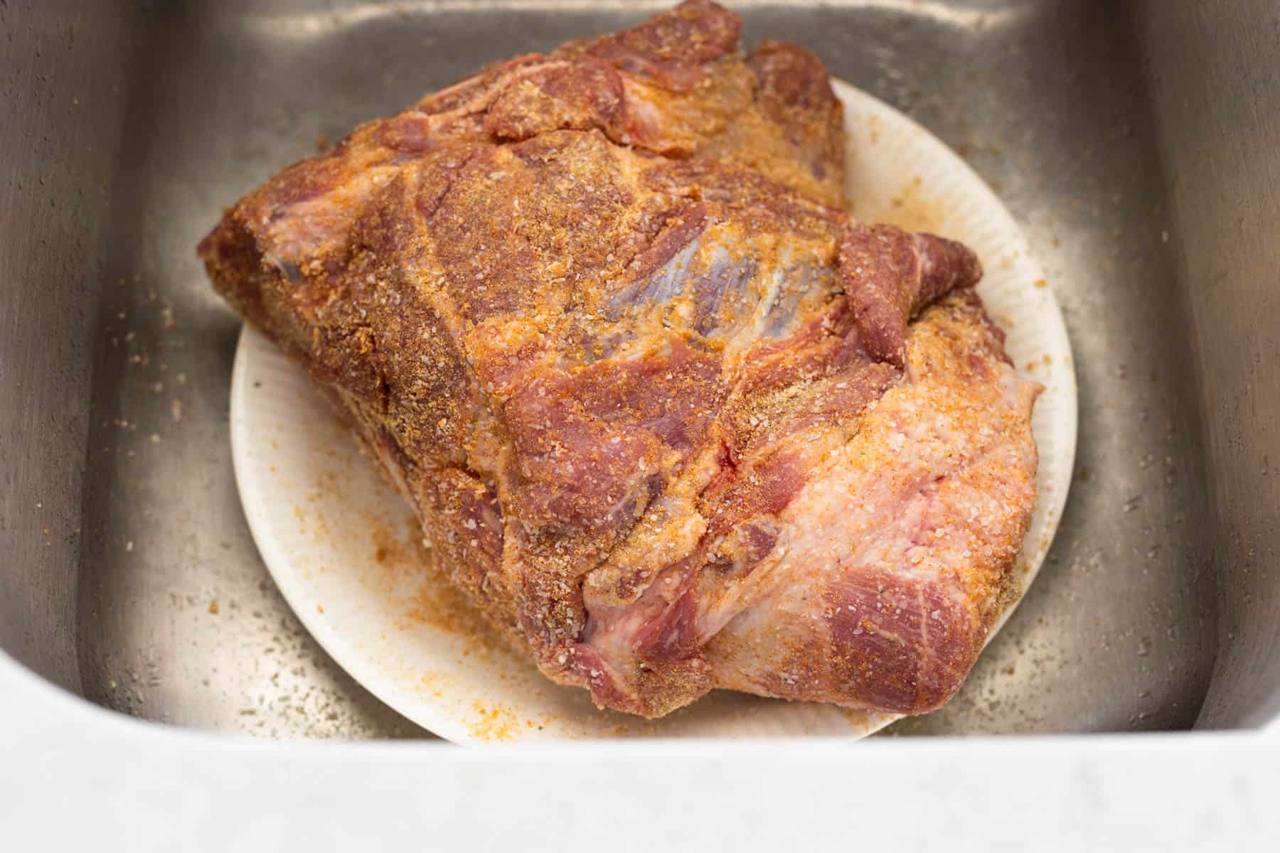 The pork shoulder has been rubbed with seasoning over all the nooks and crannies.